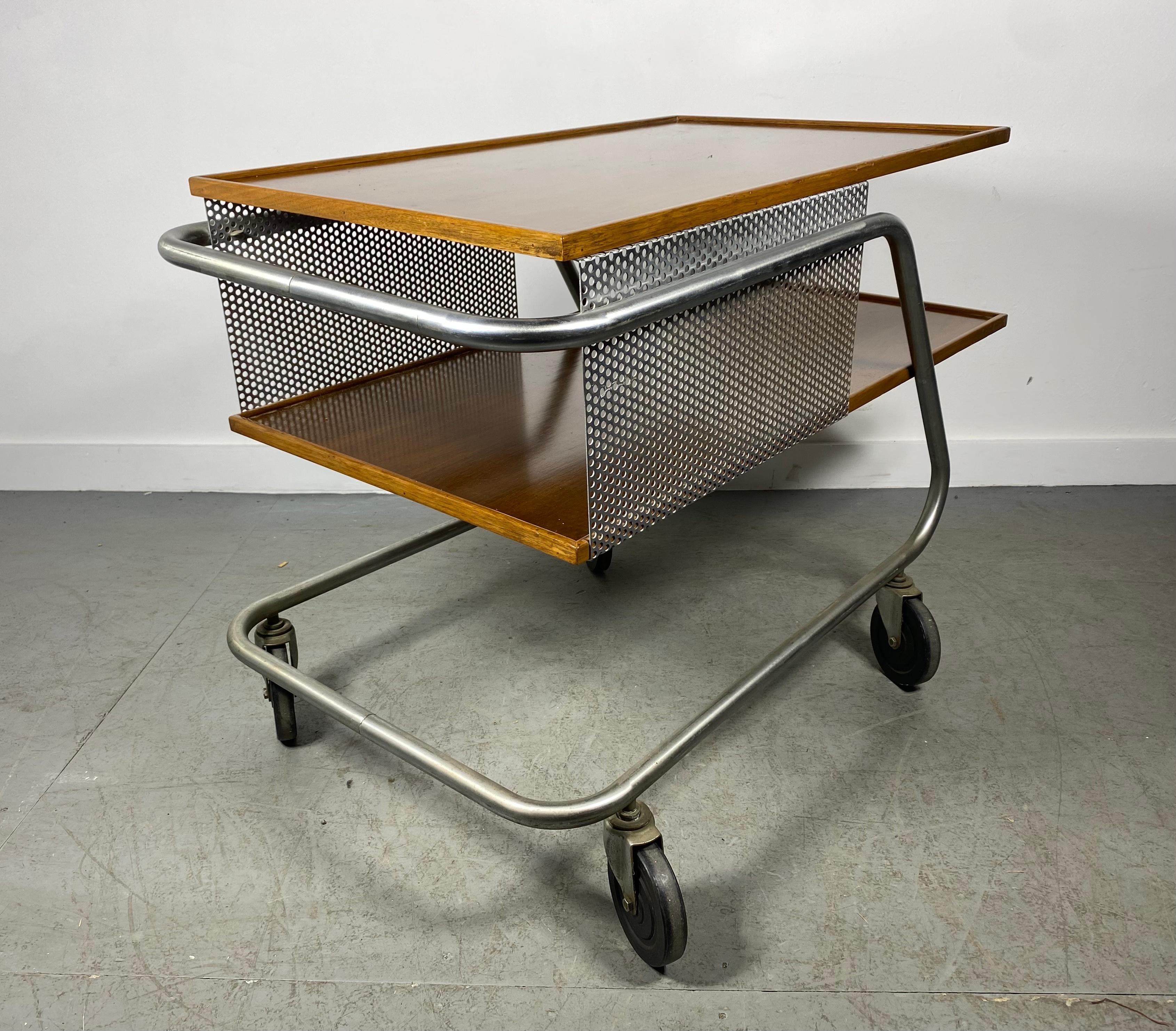 A perforated metal and wood bar / service cart with laminate top and rubber wheels rolling around on a steel tube frame. Franziska the designer studied Bauhaus design at Harvard under Gropius, Kepes, Moholy- Nagy and Breuer. This piece garnered wide