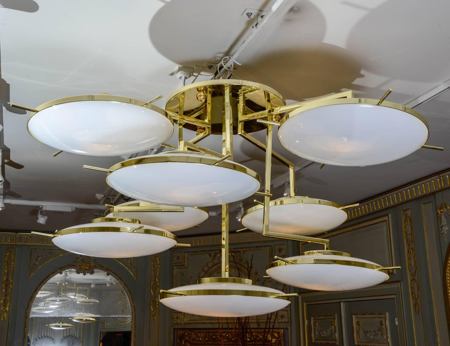 Importante lampadario in ottone con otto globi di vetro cerchiati di ottone.