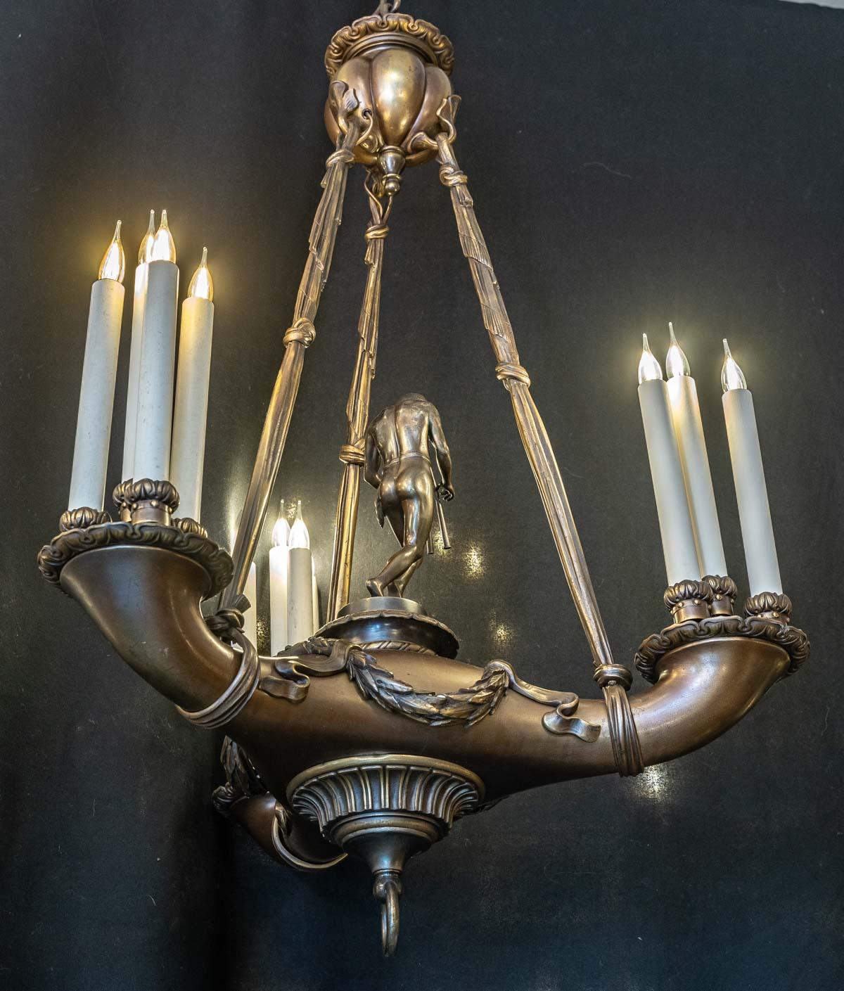 Important bronze chandelier with flute form, 12 lights, 20th century.
With chain - H: 130 cm, D: 70 cm.
without chain - H: 105, D: 70 cm.