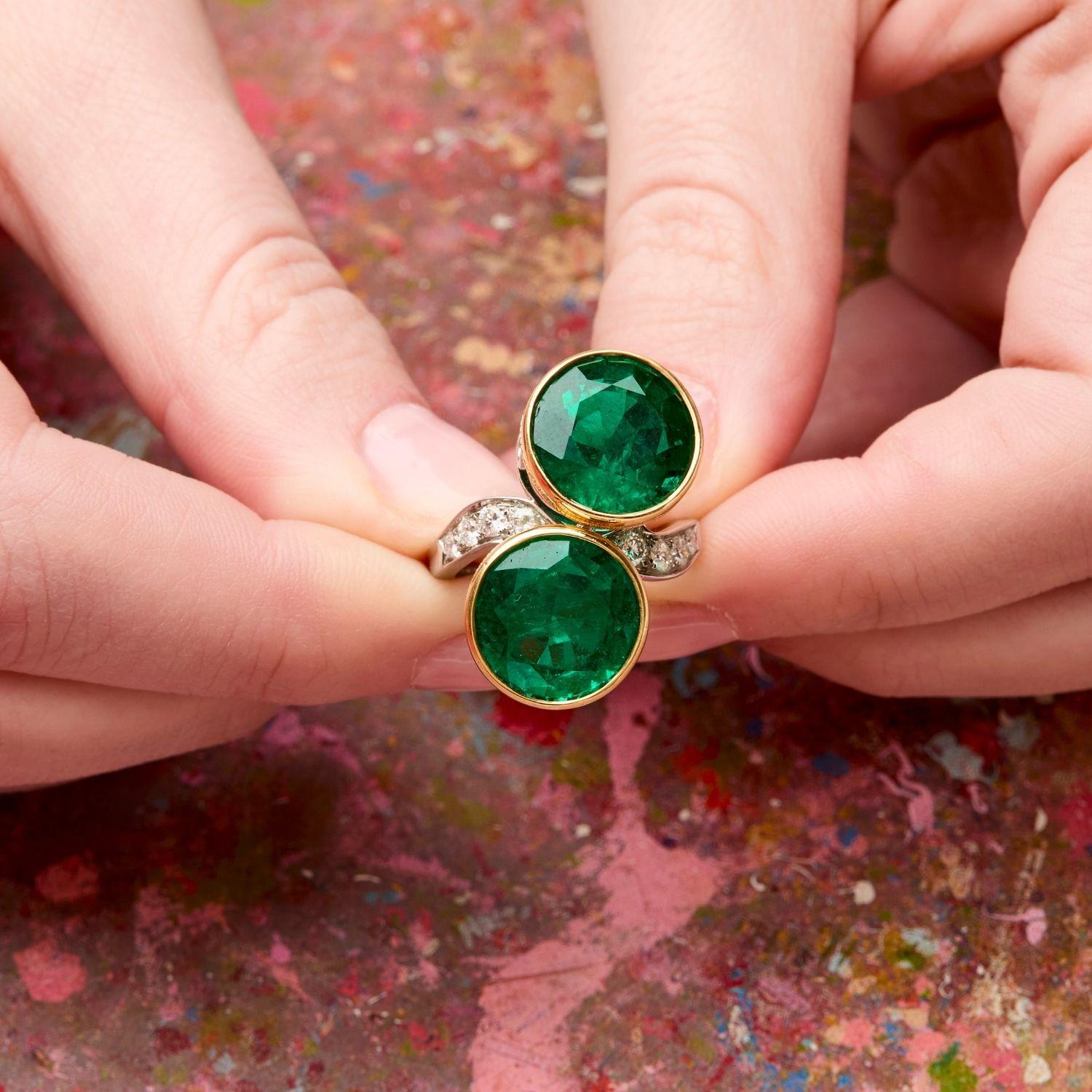 Round emeralds weighing  8.27 carats and 8.34 carats respectively cross to create a very substantial and incredibly magnificent ring. The stones are a fantastic vivid green and set into 18k yellow gold. Round-cut emeralds are rare especially in this