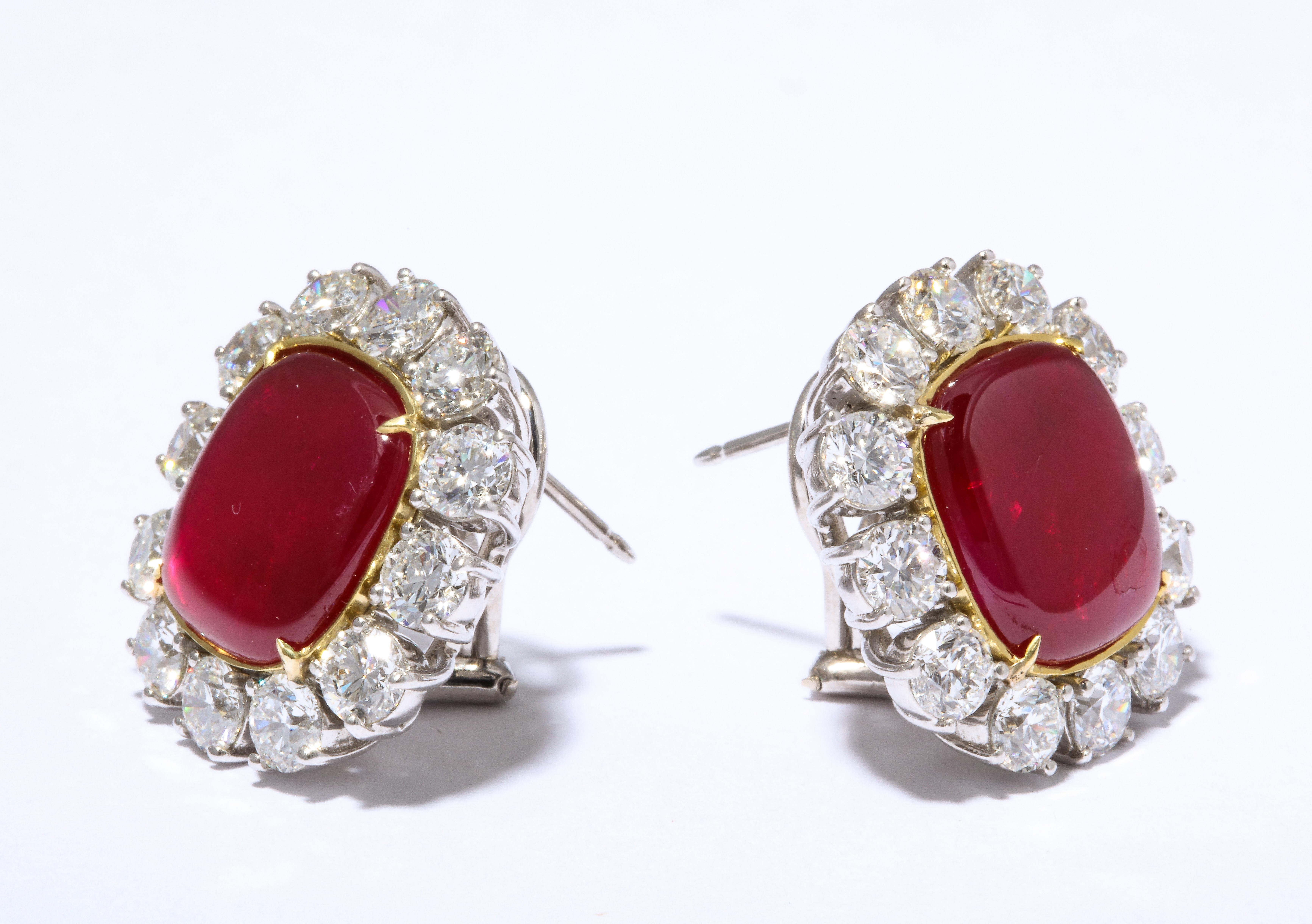 
A RARE FIND! 

A pair of perfectly matched cushion shape cabochon INTENSE RED Burma Ruby earrings. 

The rubies weigh 6.42 carats each for a total weight of 12.84 carats. 

Surrounded by 8.52 carats of white round brilliant cut diamonds. 

Set in