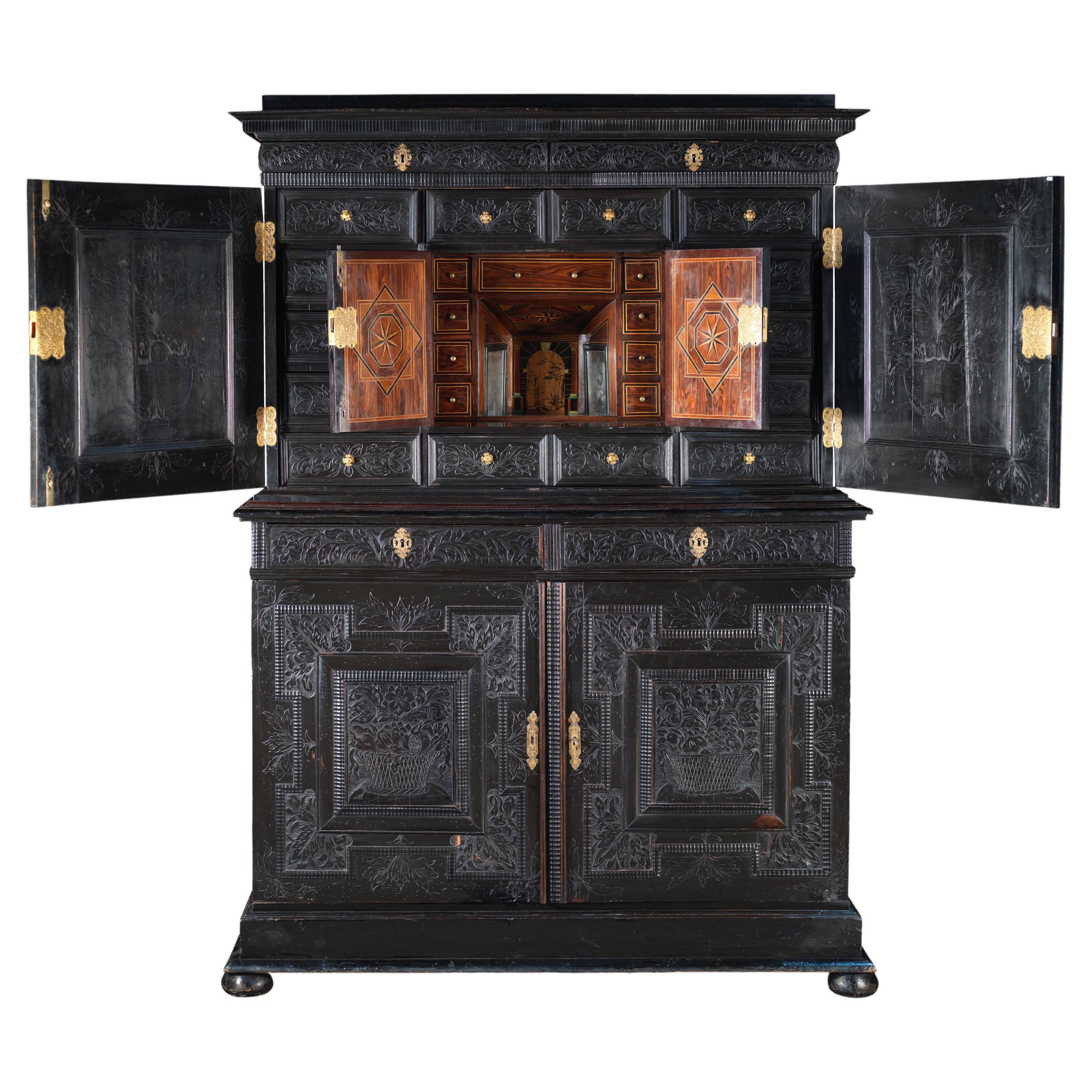 Important meuble de rangement à deux corps en bois noirci sculpté et gravé en vente