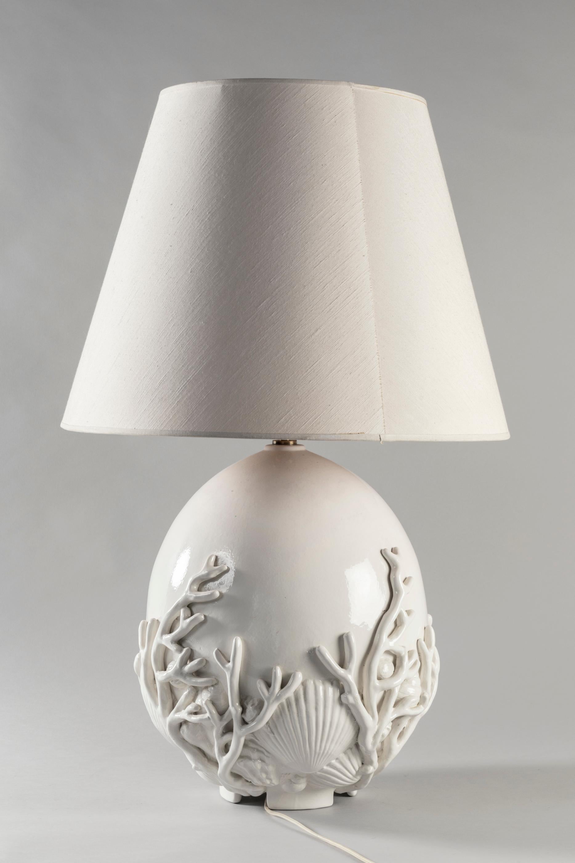 White egg shape ceramic lamp with coral and shell designs. This super elegant lamp will set perfectly in south of France interior or by the sea home. It is signed Paolo D'Anna worked for Arpex, made in Italy, circa 1970. Original lampshade.