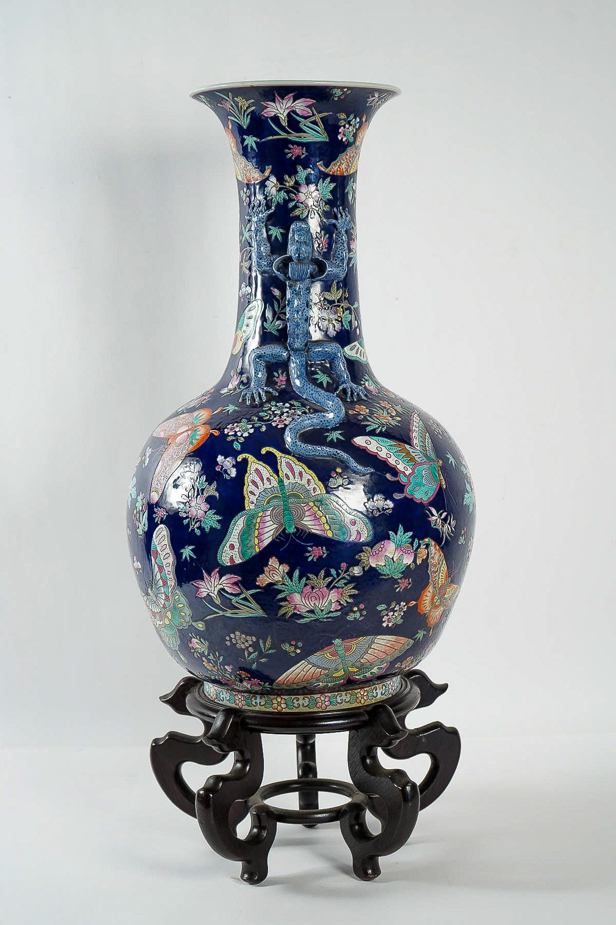 A remarkable Chinese cobalt blue stick neck vase featuring decoration of butterflies and lizards over a deep blue ground. 
Our vase rests in a wood base.

Excellent and decorative Chinese work early 20th century.

Dimensions: H 28.74 inches, H with