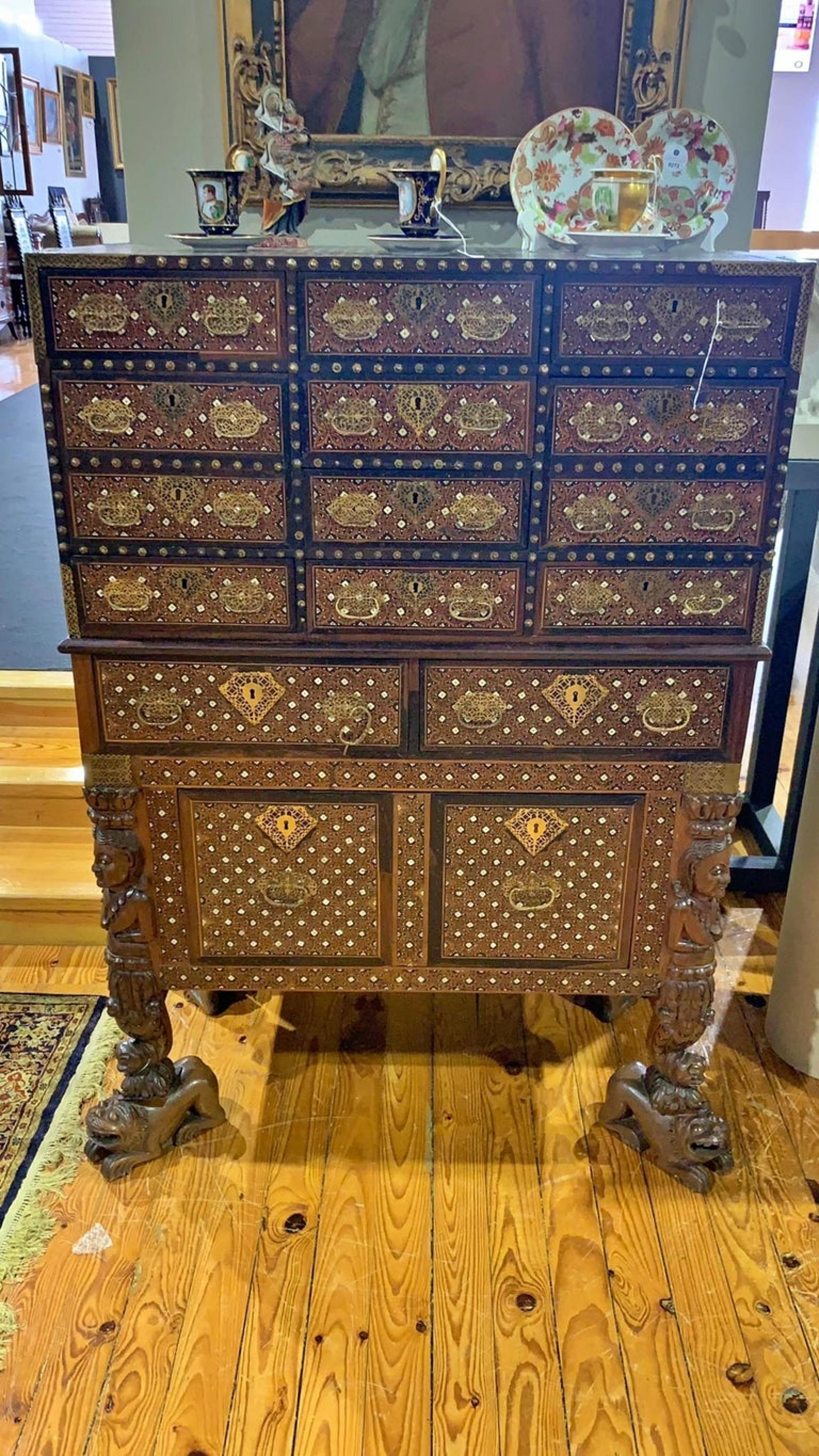 Important counter with trimpe

Indo-Portuguese 17th Century
of two bodies in ebony and sissoo.

Box with ten drawers simulating twelve drawers, resting on a base with two drawers and a large drawer supported by legs in the form of female figures,