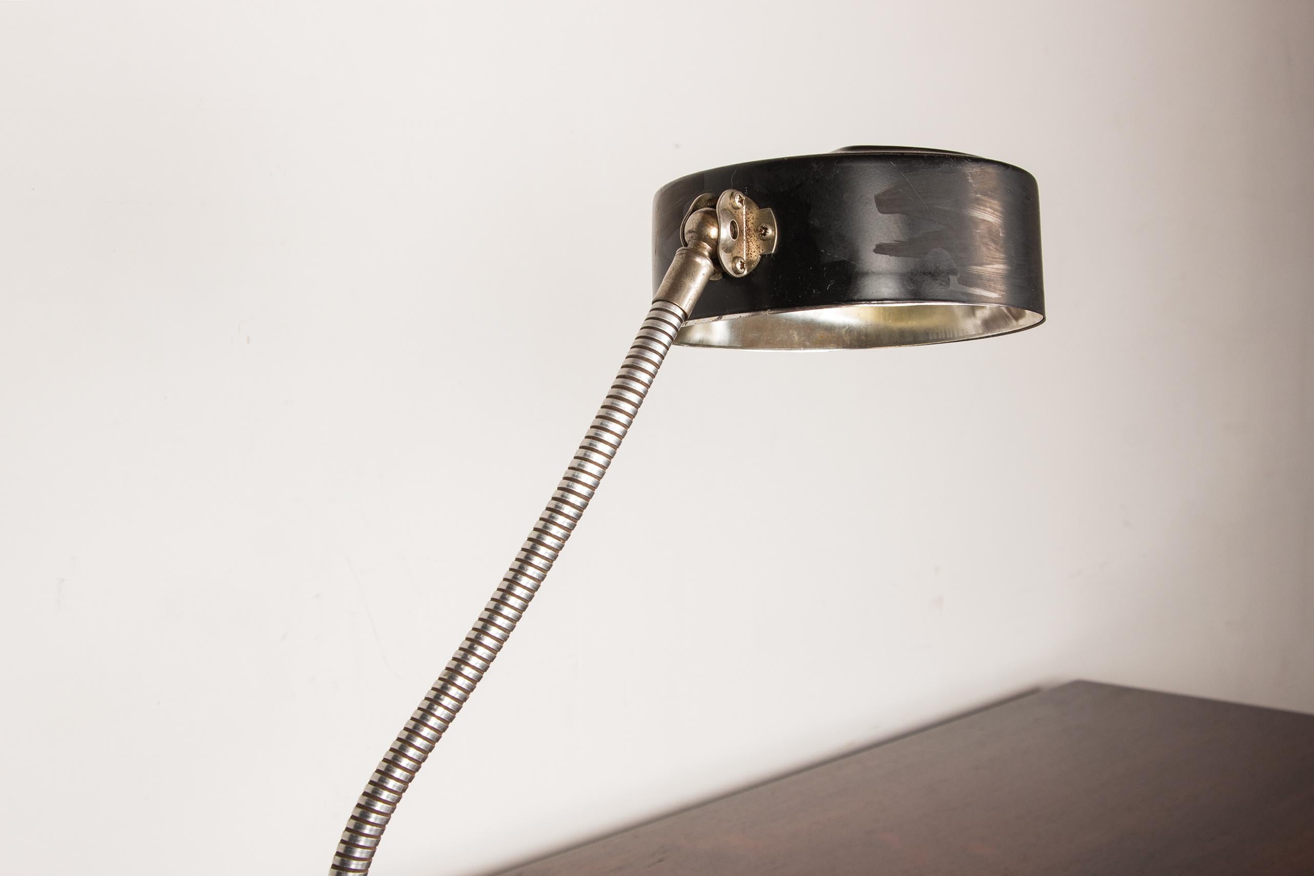 Jolie lampe de bureau de grande taille avec un bras flexible qui permet une orientation à 360° de la lumière. Couvercle et socle légers sur base sphérique.
