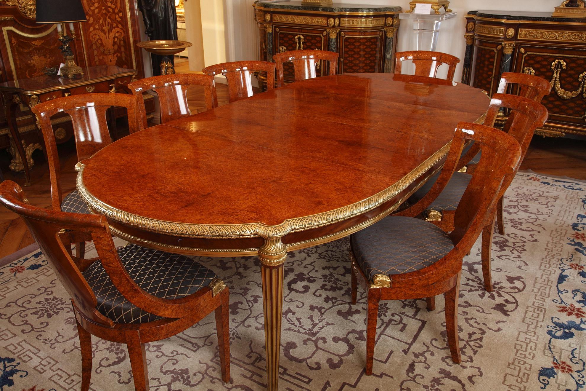 Ensemble élégant de salle à manger de style Louis XVI, composé de :

Une belle et grande table dont le plateau et le plateau sont ceinturés d'une frise en bronze doré finement ciselée, reposant sur quatre pieds cannelés en laiton.
Mesures :