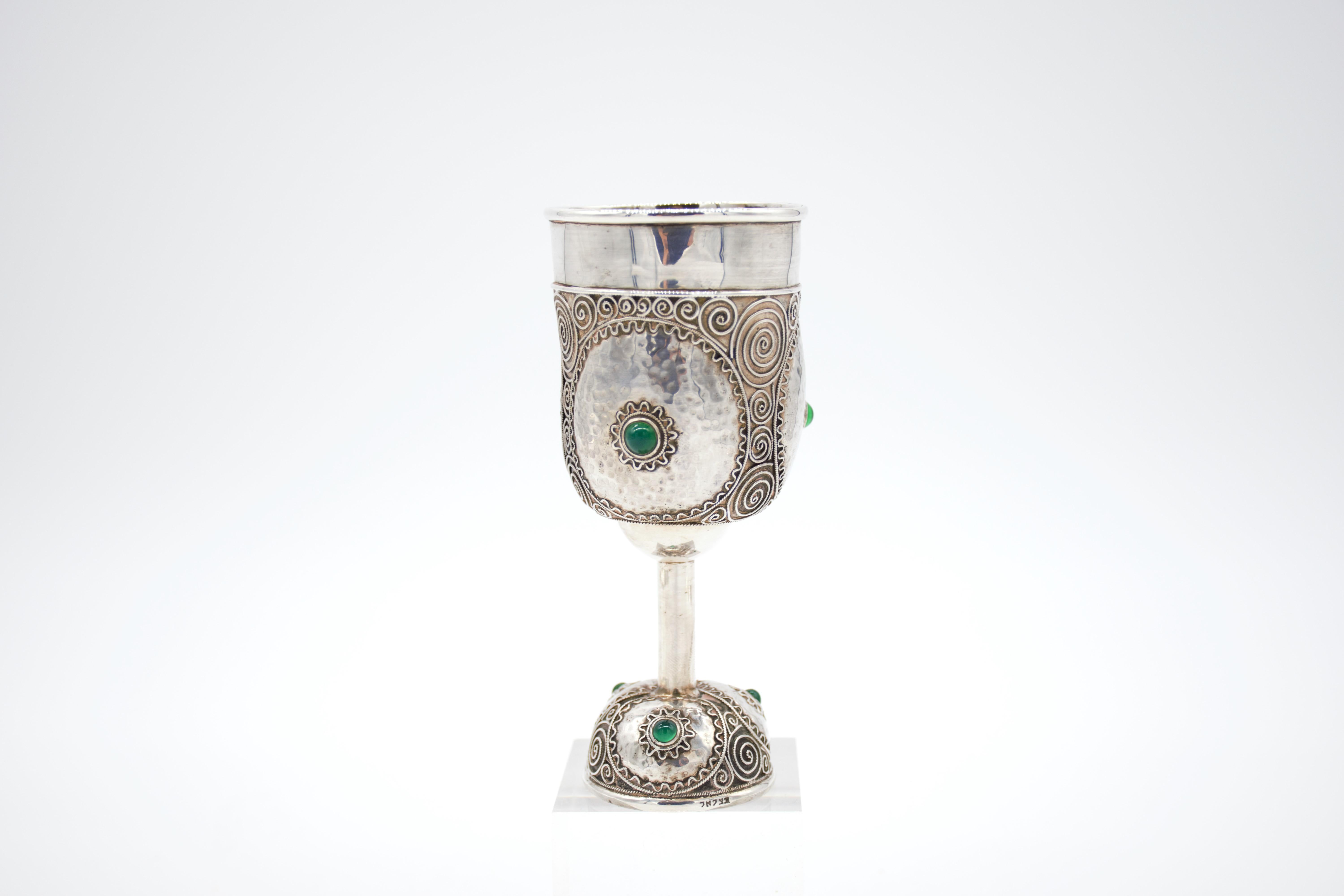 Important Handmade sterling silver Kiddush goblet by Bezalel School, Jerusalem, circa 1910-1913. 
On round base decorated with silver filigree and Cabouchon shaped green agate applications. 
The base fitted with Bezalel mark. The upper portion is
