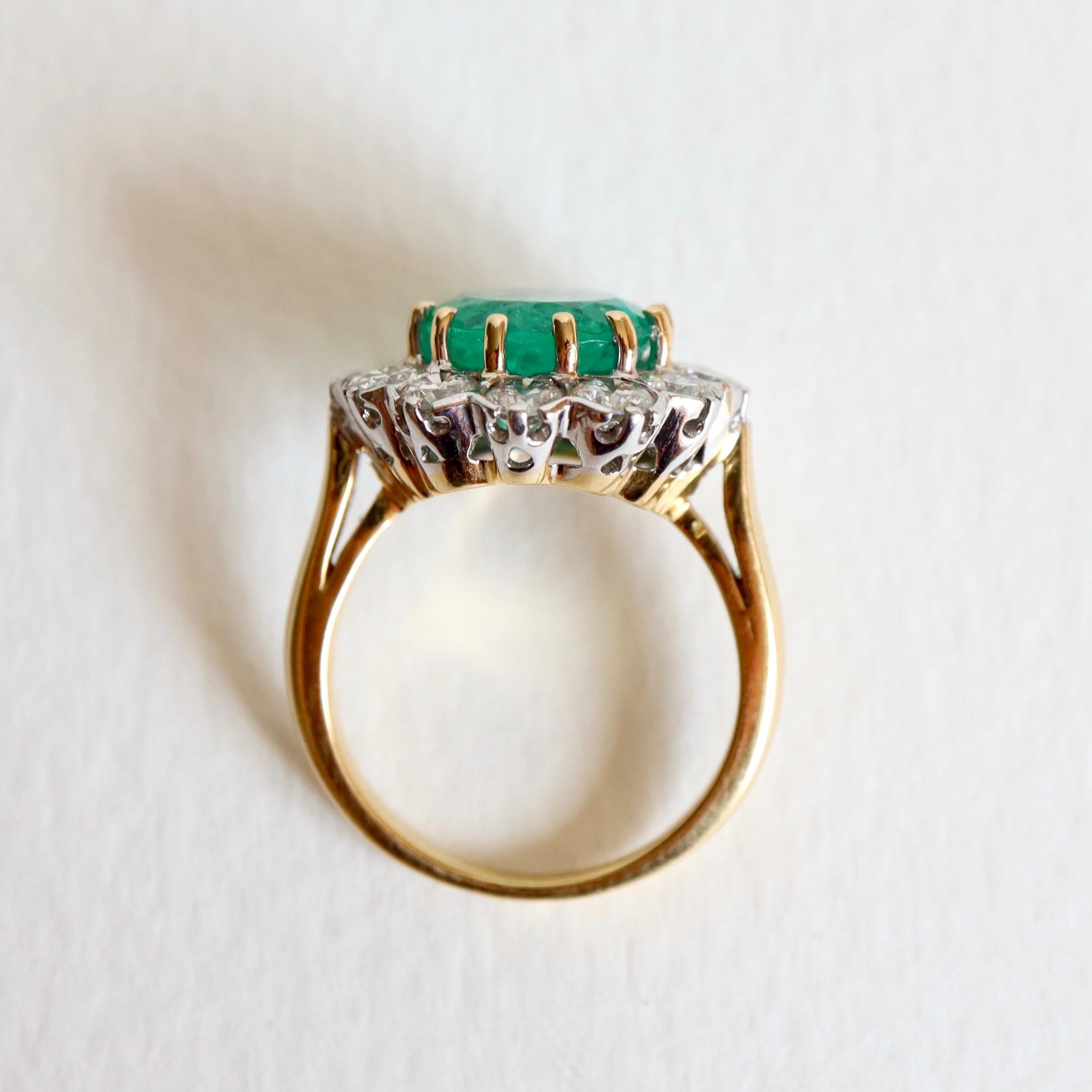 Pompadour Model Ring in 18 carat yellow Gold setting in its Center a large Oval cut Emerald set with Claws weighing 4.53 Carats surrounded by 12 Diamonds of approximately 0.15 Carat each mounted on 18 Carat white Gold Chatons for a total Weight