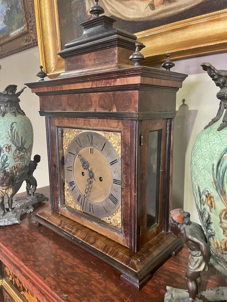 Table clock
English, 19th century
George III style. 
Kingwood veneered box. 
Metal dial with brass inserts. 
Roman numerals. 
Running mechanism not revised. 
Minor defects in the box. 
Dim.: 66 x 45 x 21 cm
Very good condition.