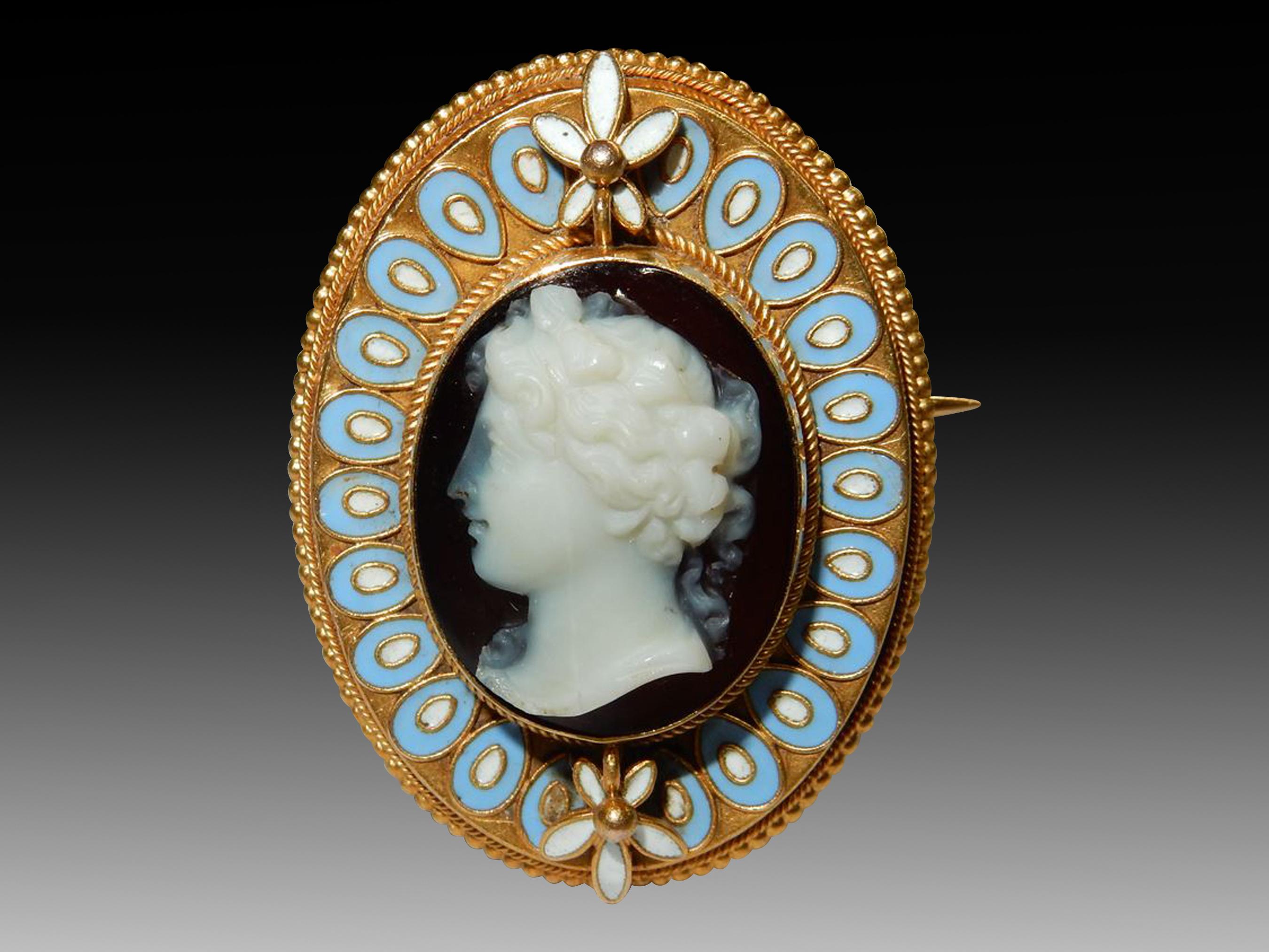A high-quality gold hardstone cameo (Circa 1860) depicting a classical roman lady, probably a deity or Bacchante. The detail is magnificent, with intricately hand-carved hardstone coupled with fine gold wirework and beading. The blue and white