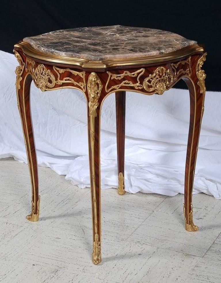 The Following Items we are Offering is A Magnificent European Louis XV Style Mahagony and Bronze Ormolu Mounted Carved Ormolu Mounted Wooden Marble Top End Table. Table is intricately detailed with Bronze Cherub Mounts and Ornately Mounted. Taken