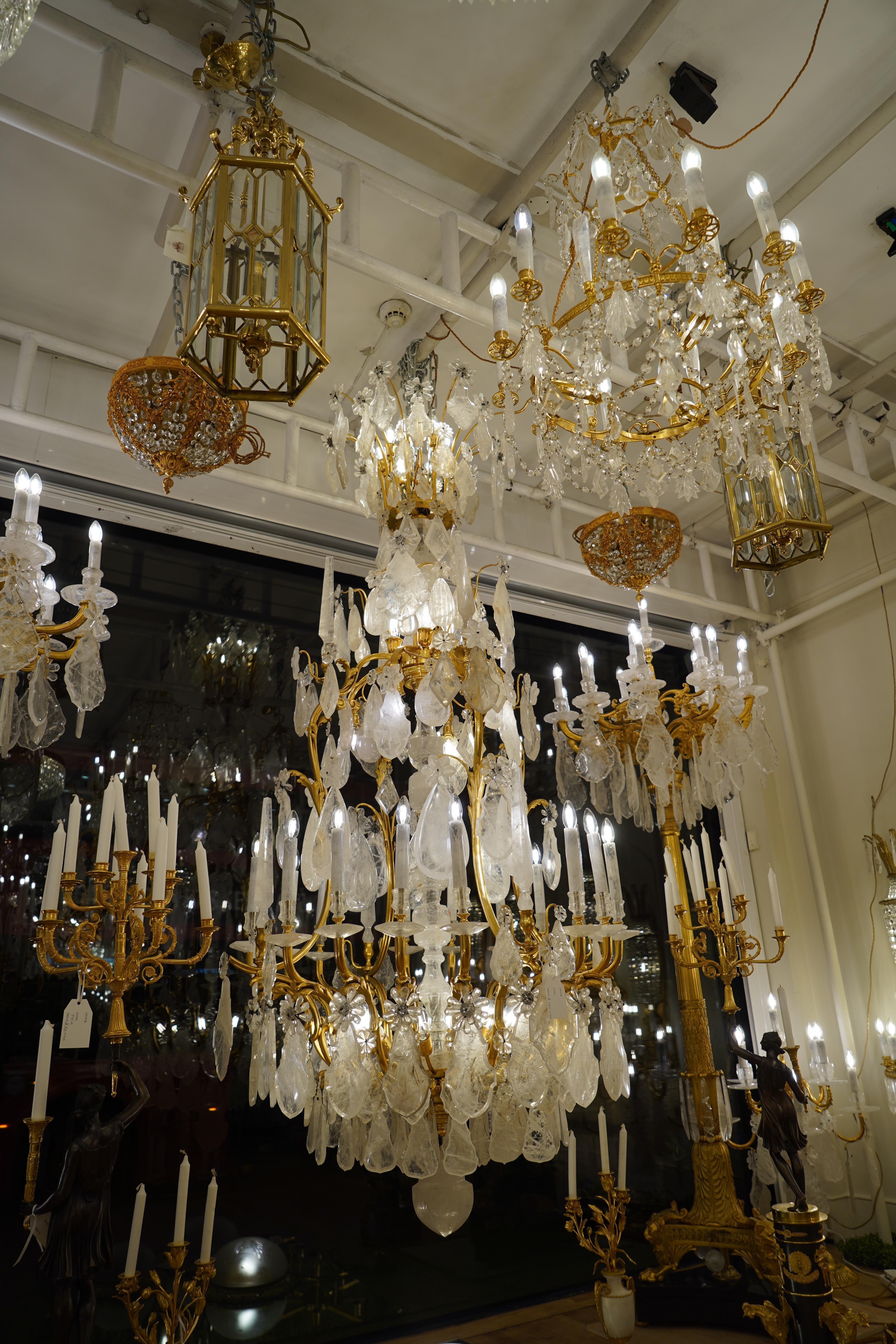 Of cartouche outline, with rock crystal baluster shaft with acanthus scroll branches of light and spires, hung with large rock crystal plaques, facetted drops and rosettes, terminated with a rock crystal ball. Professionally rewired for