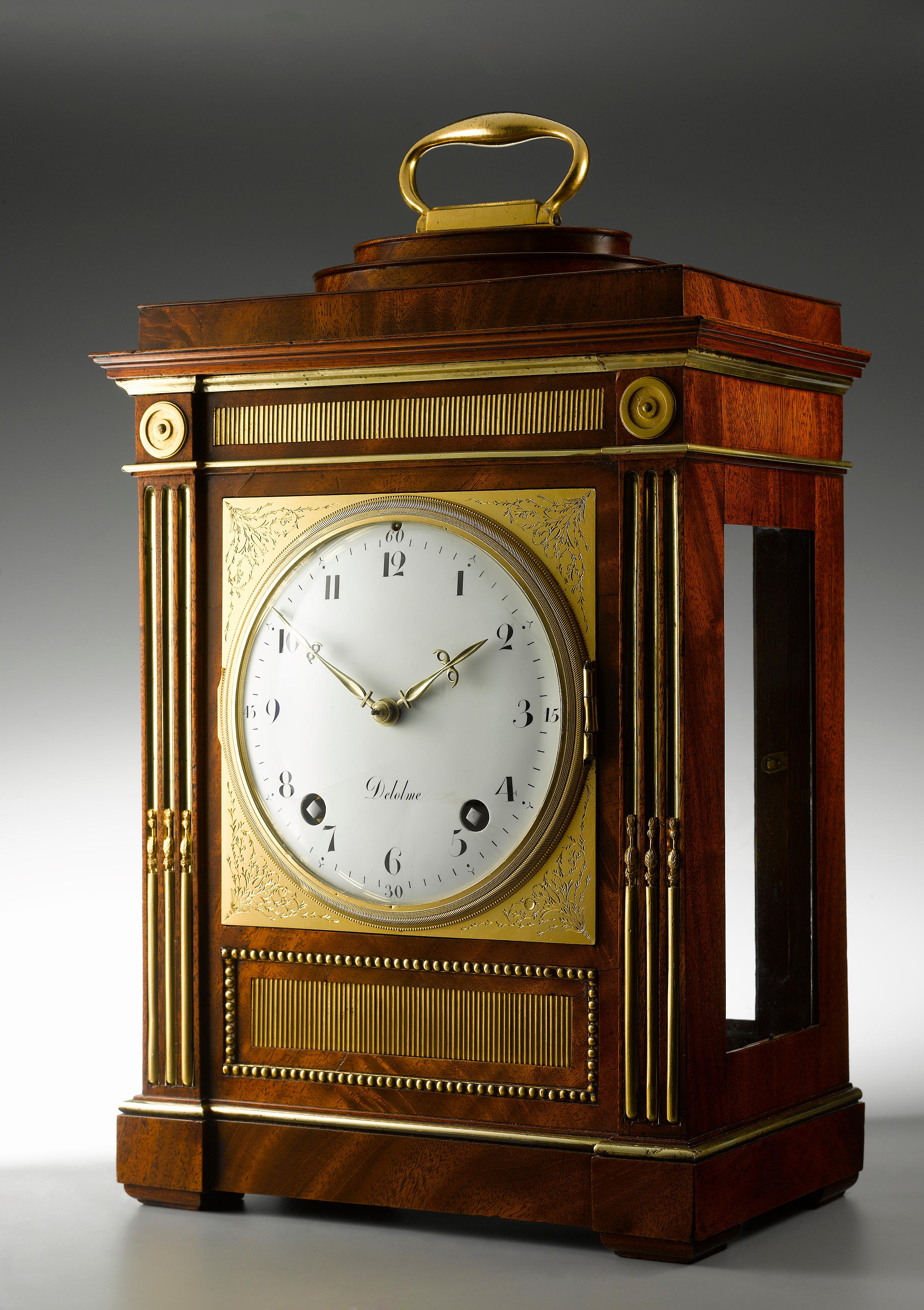 An important and rare table clock from the workshop of David Roentgen. The case with an oval stepped plinth top with gilt bronze handle, decoration of the case with ormolu mille raie banding, beaded edges and brass fluted columns to the front