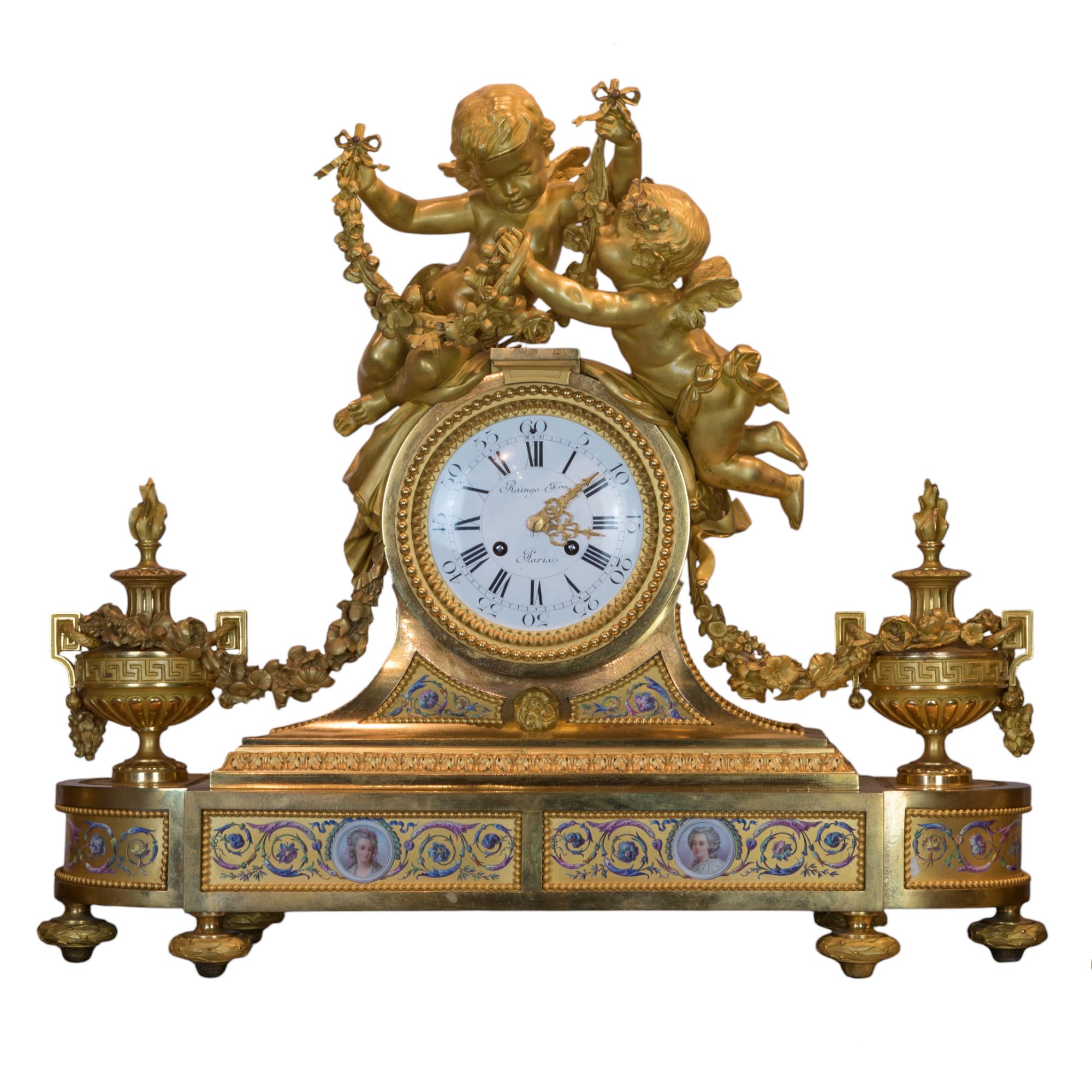This exquisite 19th-century fine gilt-bronze clocks garniture by Joseph Raingo is a masterpiece of craftsmanship and design. The set features a central clock adorned with intricate figures of cherubs, who are depicted in dynamic poses, adding a