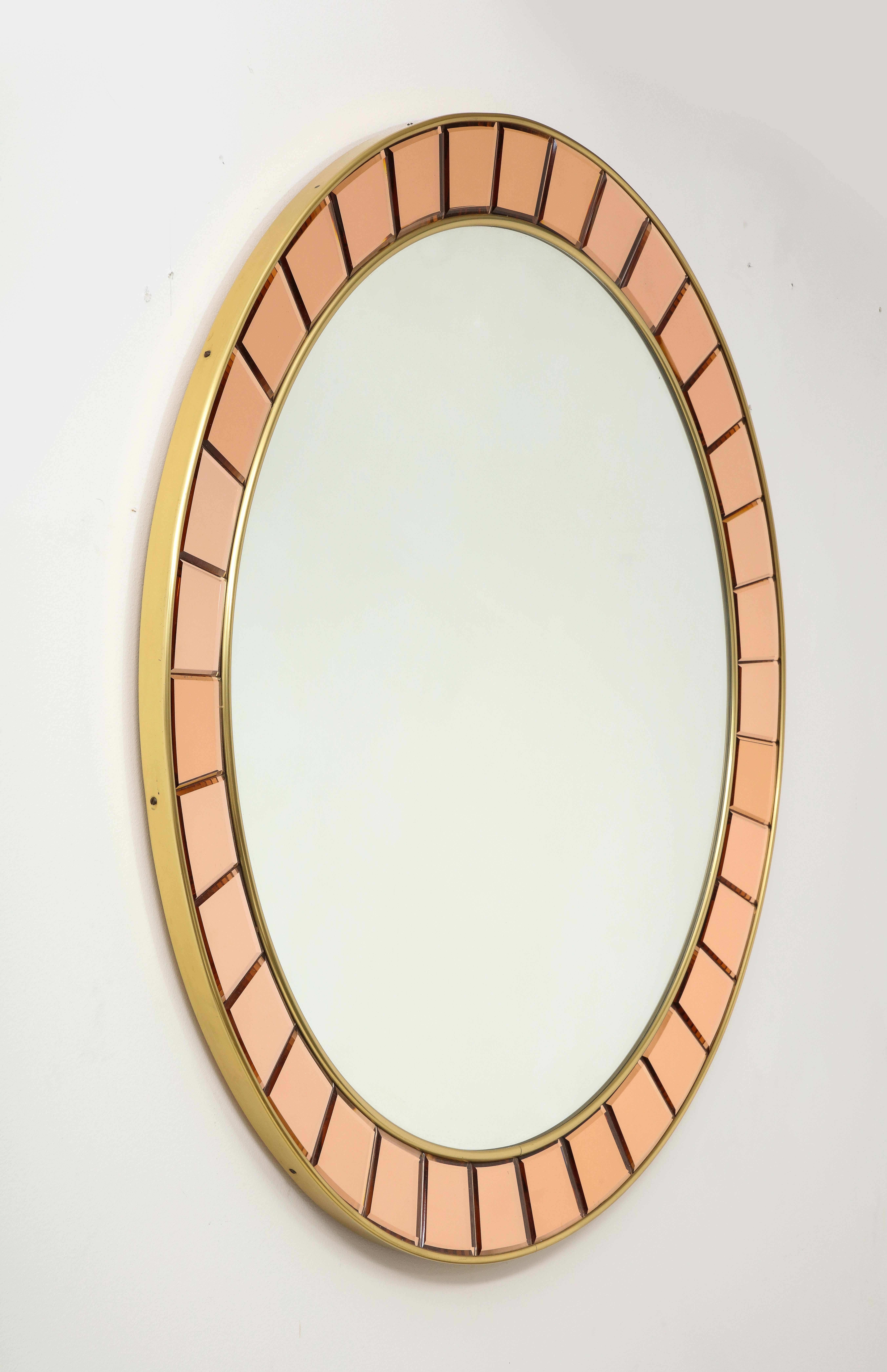 Cristal Art important and elegant large circular mirror model 2679 with hand-cut, beveled crystal glass pieces framed by gilt brass borders and mirrored glass on a wooden backing. The color of the faceted glass is an exquisite rose which is