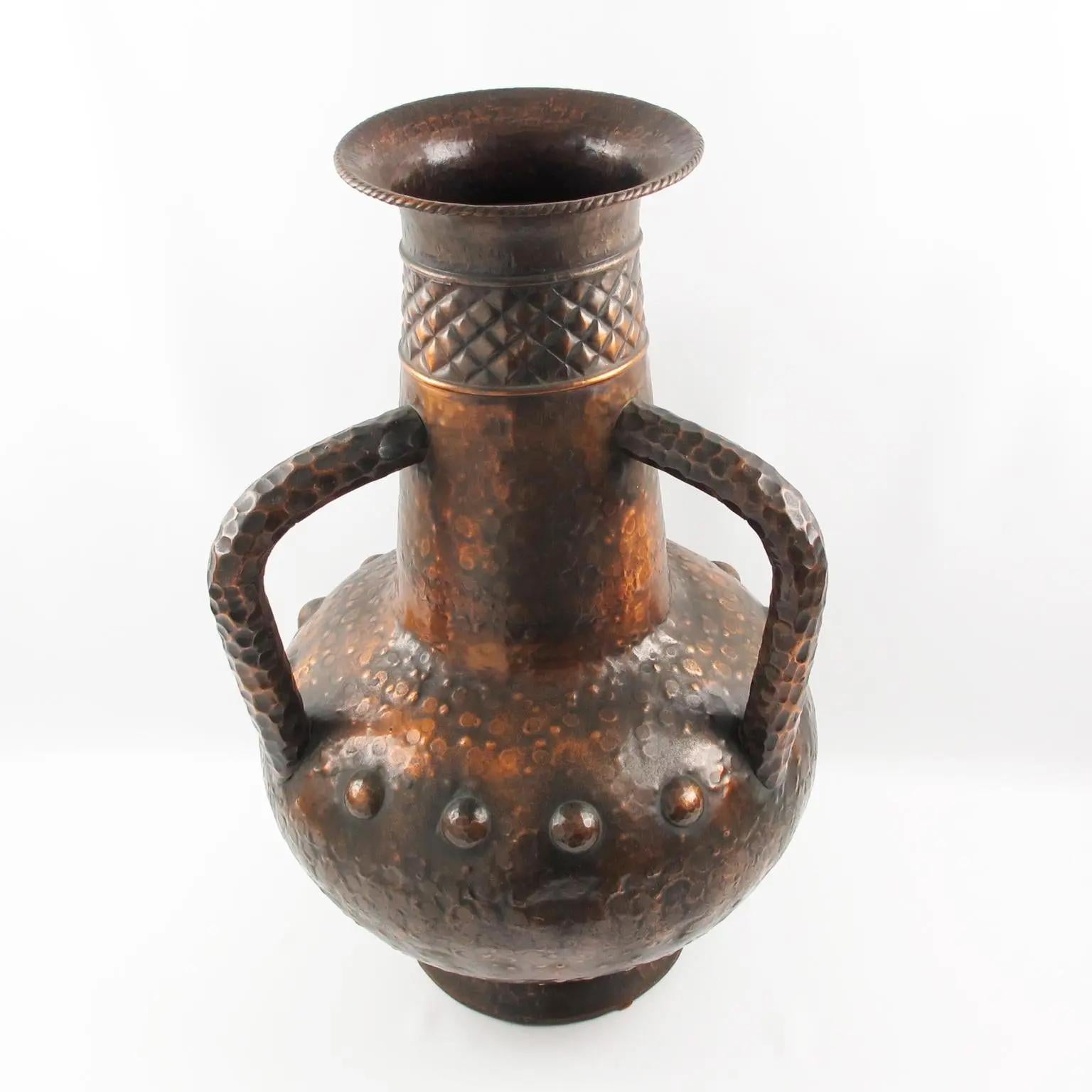 Ce vase monumental en forme d'urne balustre avec poignées a été fabriqué à la main en Italie dans les années 1960. Les détails travaillés à la main sur le cuivre, ainsi que sa belle patine, confèrent à ce récipient un attrait unique. Le vase