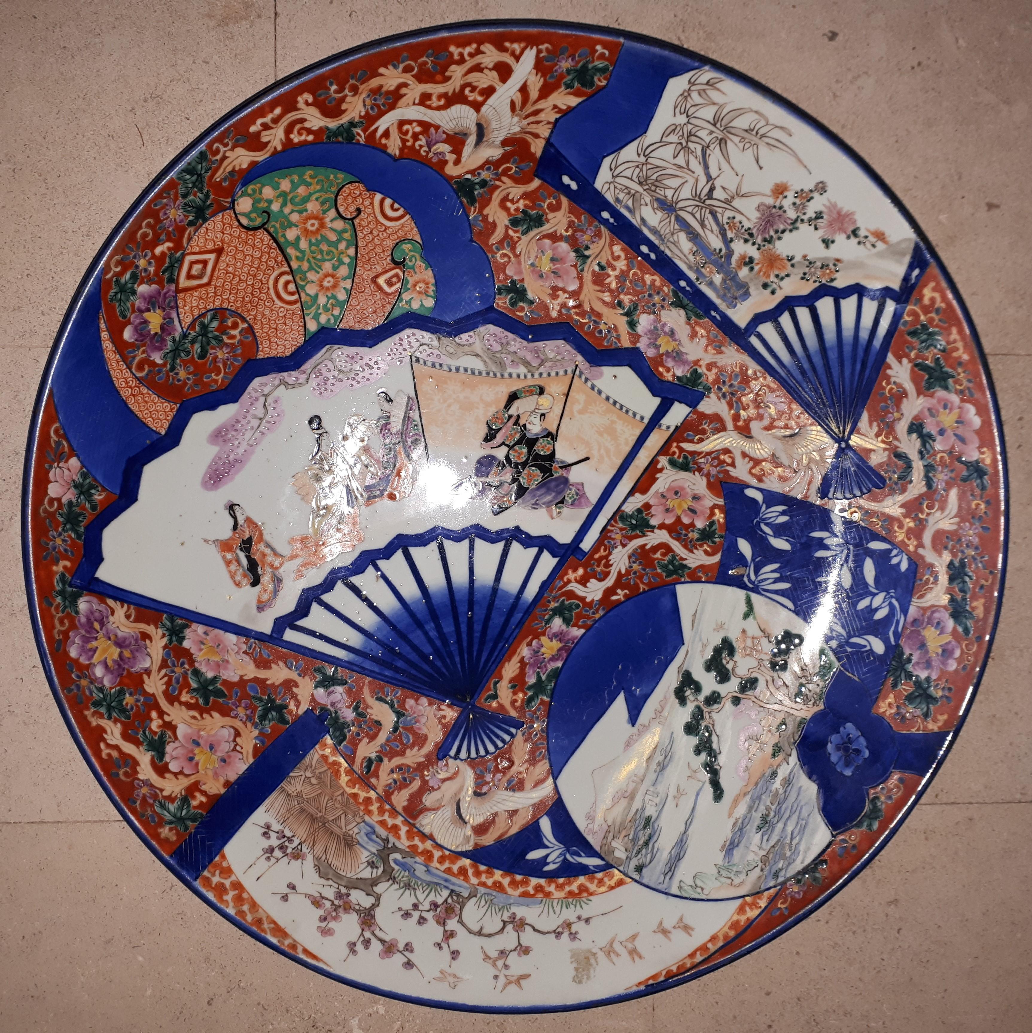 Important Arita porcelain dish, with polychrome decorations in blue reserves of different shapes, the coral background embellished with phoenixes and flowers. Japan, 18th century.