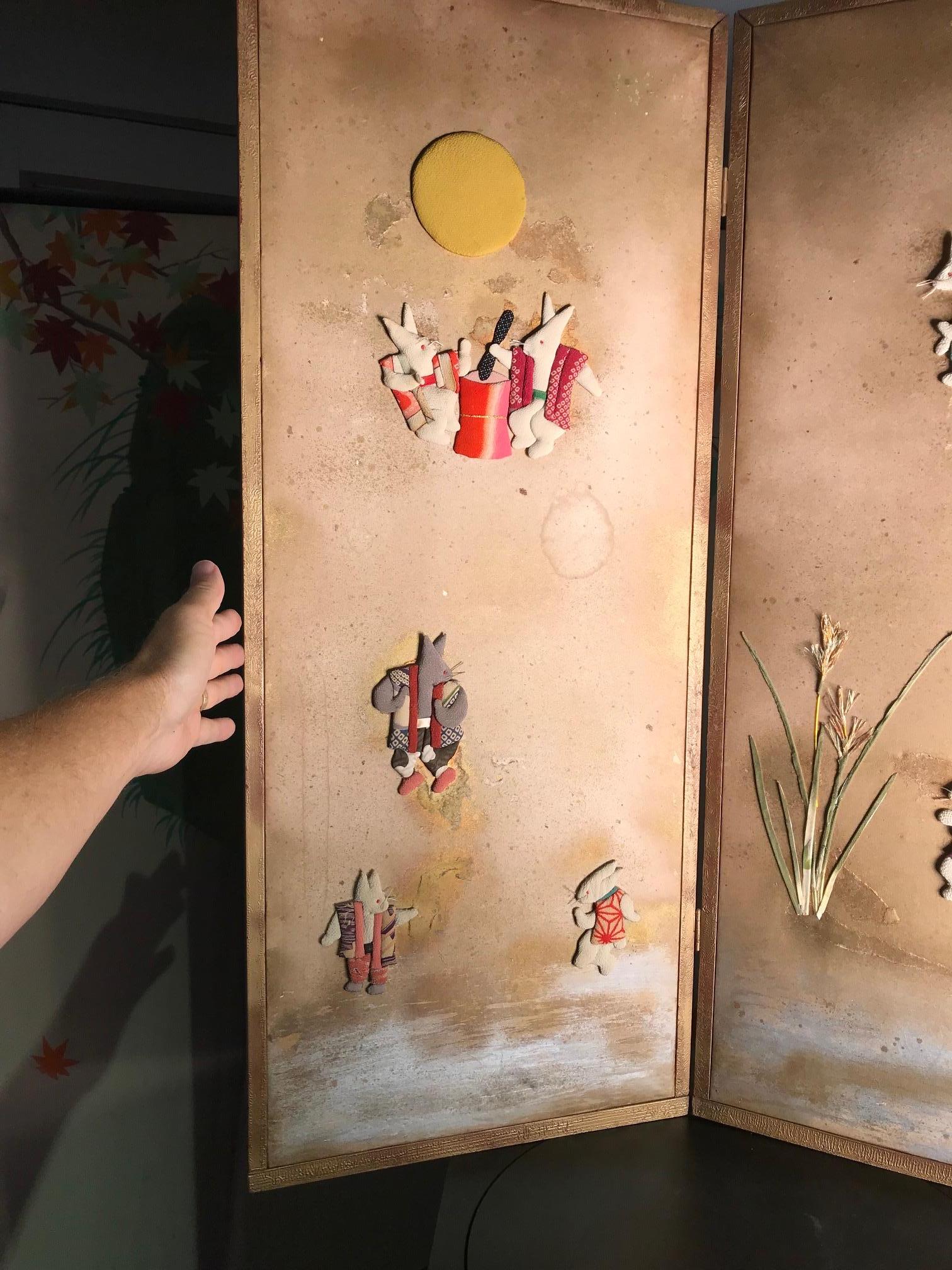 Japan, a beautiful and unusual two-panel screen Byobu with nine hand embroidered Rabbits including fantastic -moon rabbits appliqués -Shushu- applied to its cream colored paper surface and finished with a silver cloud like back ground. It has been