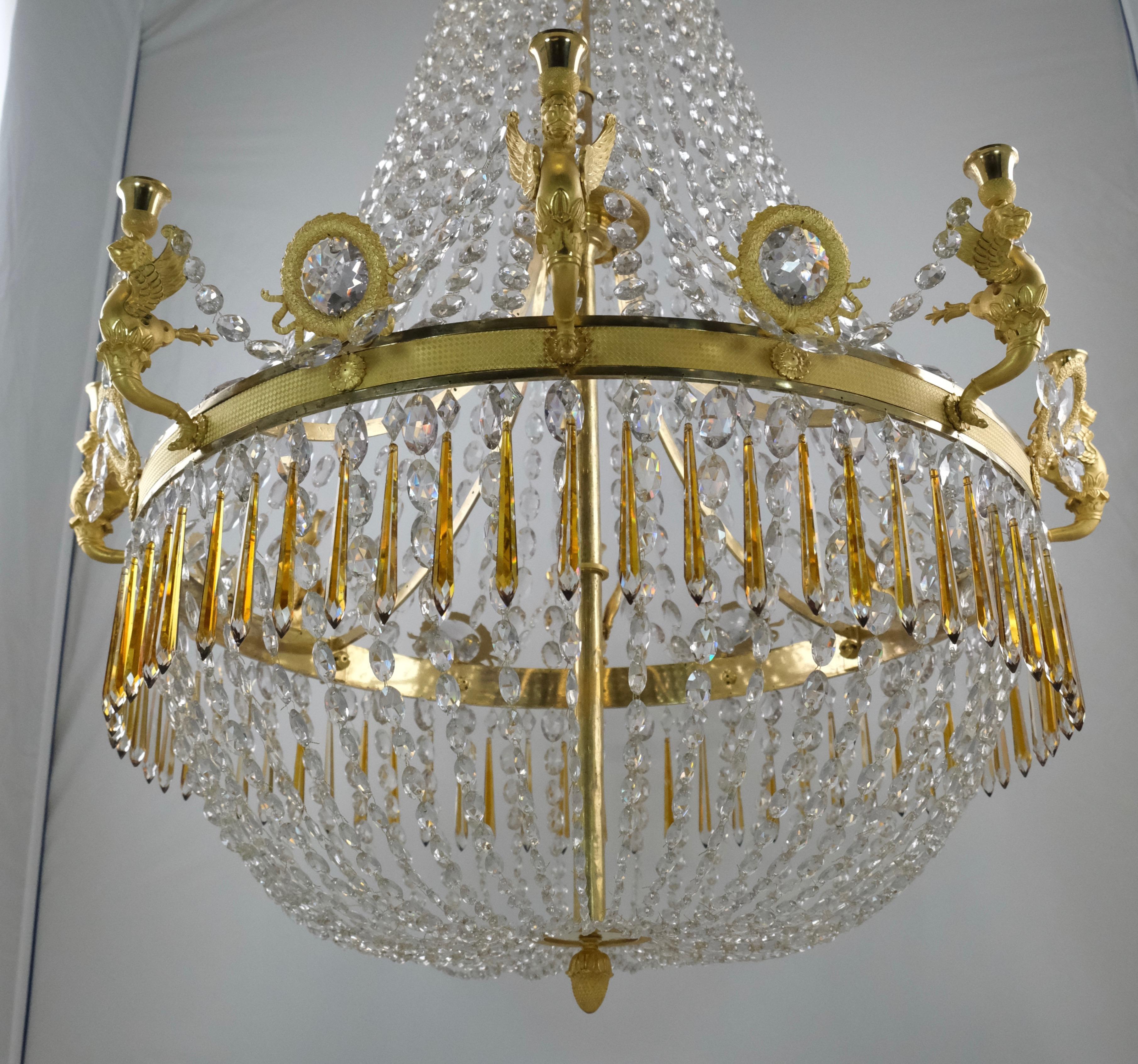 A fantastic large Empire chandelier. Made of gilt bronze of the highest quality both to the casting, the enchasing, the gilding and especially the design with the amazing large arms shaped as bewinged lions. This type of early empire chandeliers are