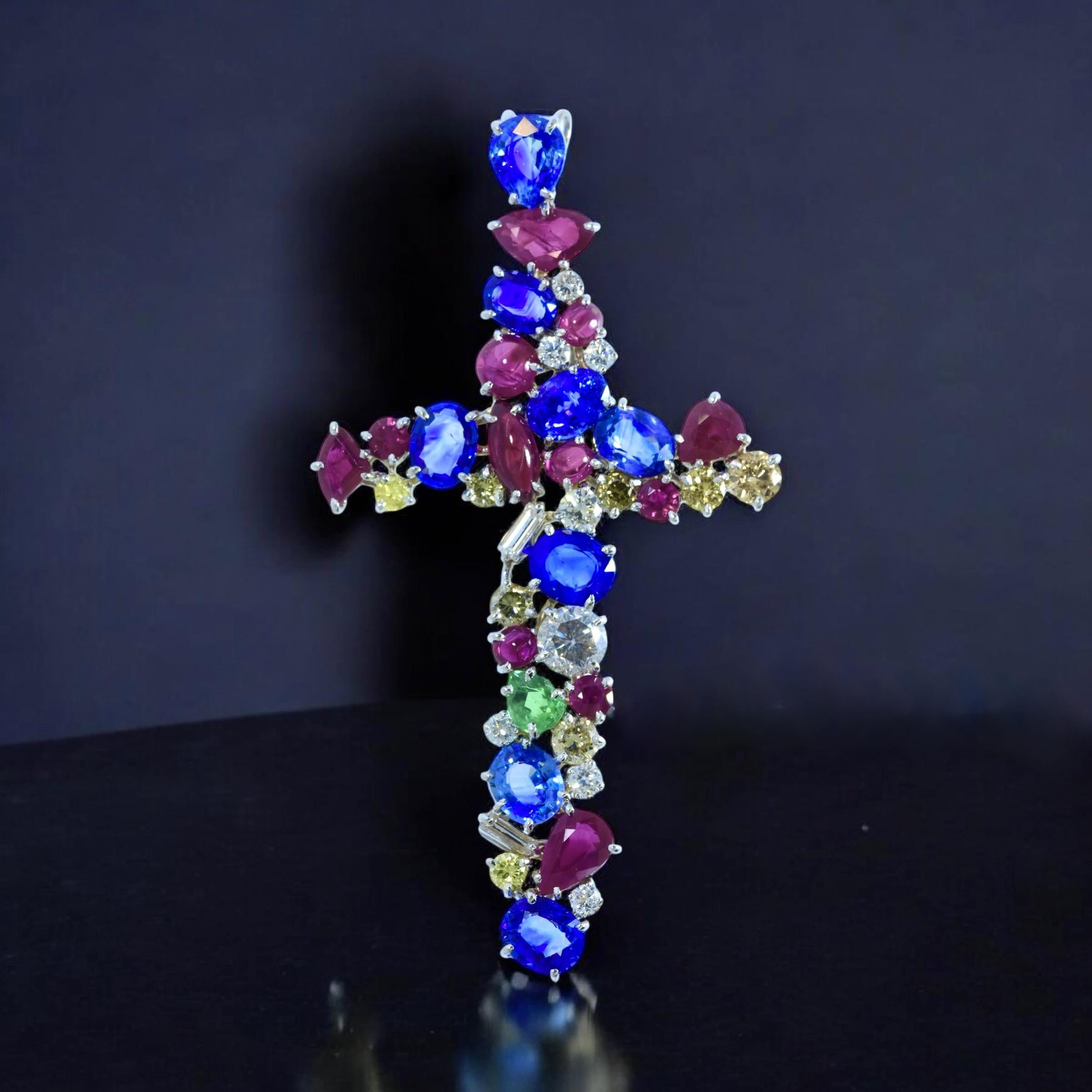 Cross Pendant set with fine diamonds and gemstones. Seemingly at random in a juxtaposition, thirty eight white diamonds, colored diamonds and colored stones are prong set in no particular order in this 18 carat white gold cross. Just as there is