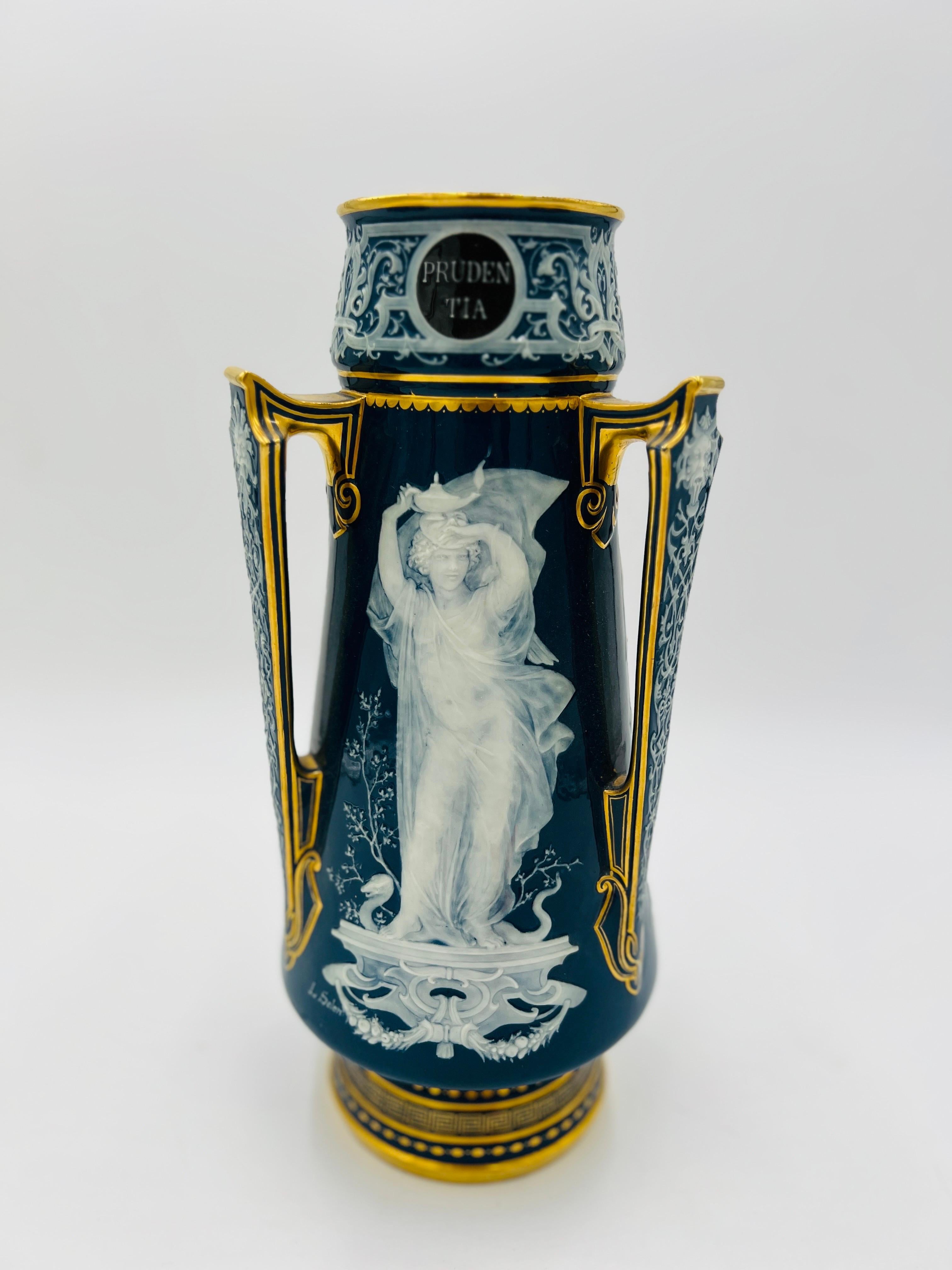 A highly unusual Louis Solon Mintons vase with peacock blue porcelain ground, Pate-Sur-Pate 3 panel decoration to body each depicting one of the “Cardinal Virtues”. 

Robur for Stength
Prudentia for Prudence 
Justitia for Justice for All

The