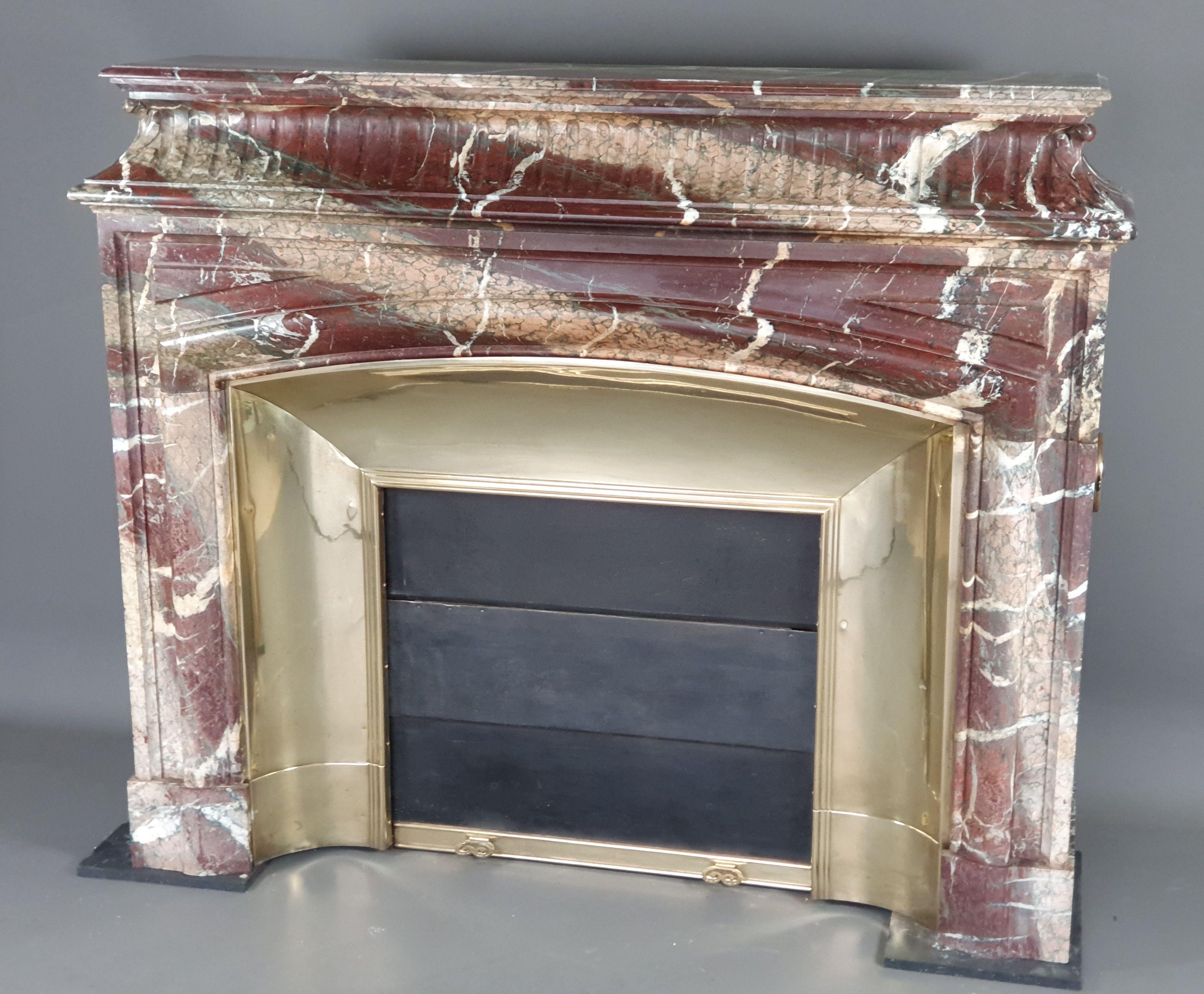 Important Louis XIV style fireplace with acroterion and boudin.

Acroterion decorated with large grooves and plant-inspired decorations on the spandrels. Presented with its polished brass shrunken and retractable trifold door (complete with its