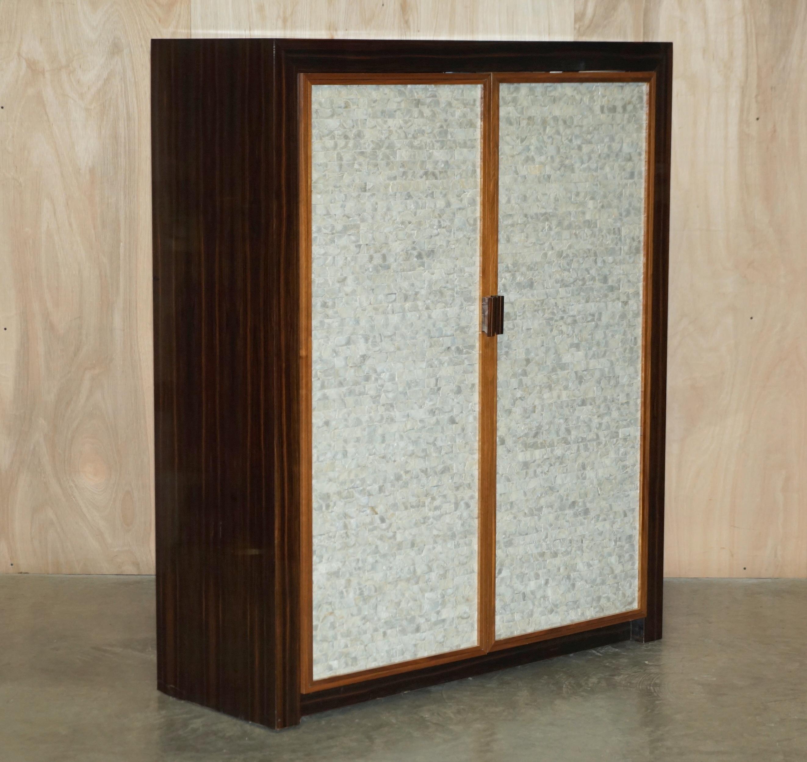Nous sommes ravis d'offrir à la vente cette très, rare et importante armoire en ébène de Macassar avec des panneaux de porte en nacre, des étagères vitrées et des panneaux latéraux et arrière en miroir.

Je n'ai jamais vu une telle pièce