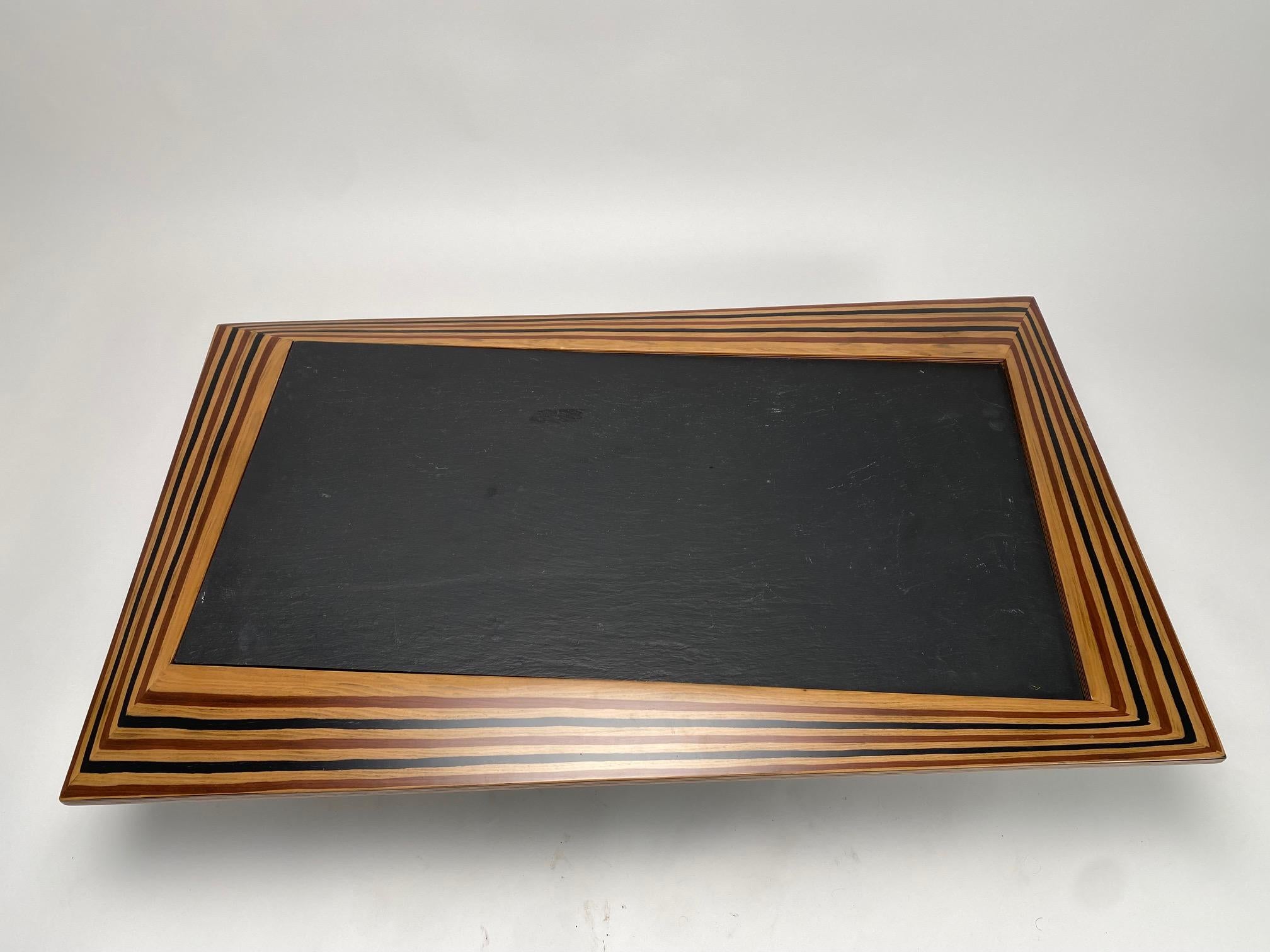 Rare and extraordinary coffee table with very thick slate top and irregularly shaped walnut wood frame.

 It is an original and highly refined work of complex cabinet-making, which in terms of style and geometry recalls the best production of the