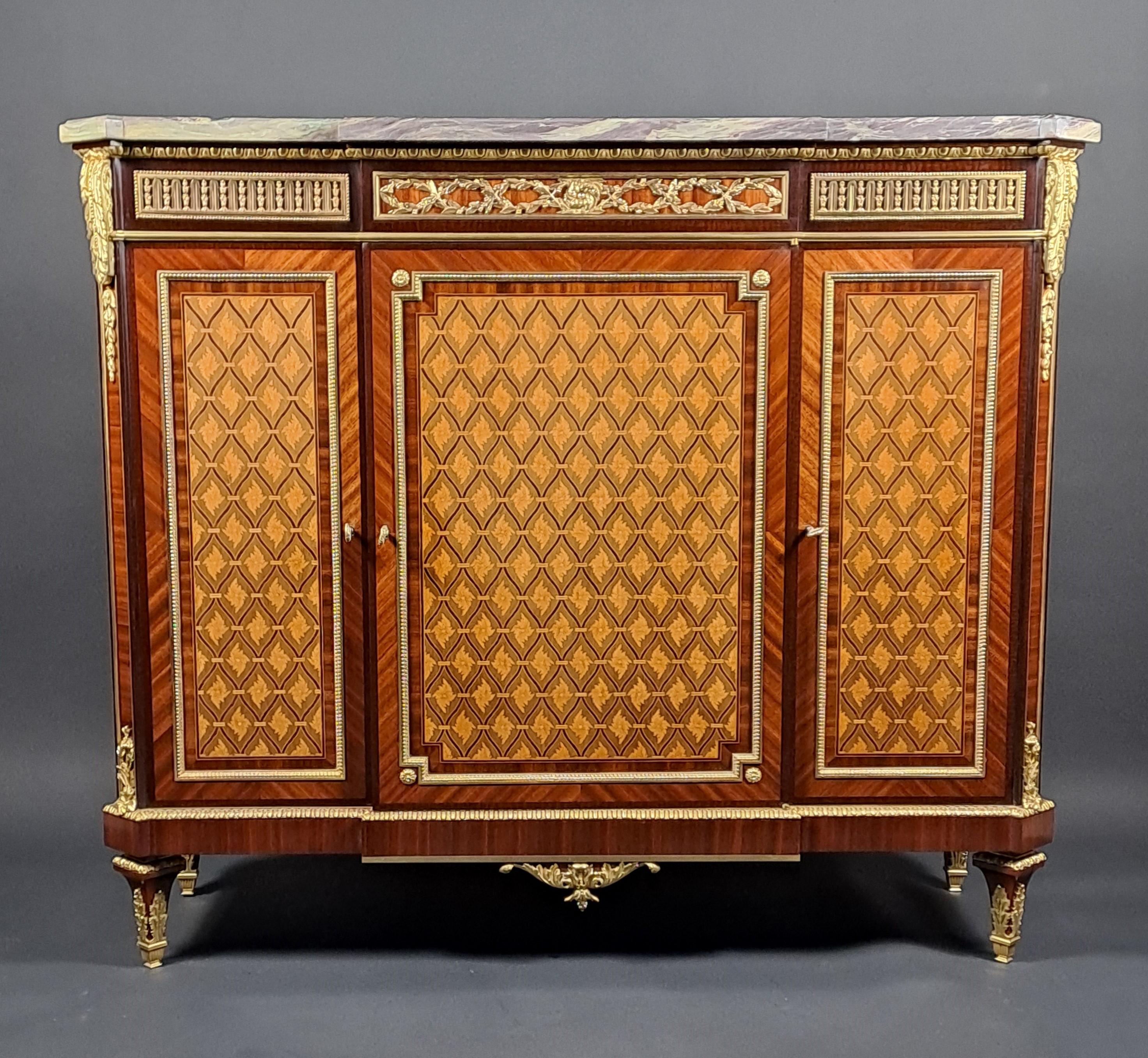 Grande credenza in stile Luigi XVI con sporgenza centrale che presenta una ricca decorazione a intarsio, con traliccio che racchiude motivi di ispirazione floreale sul fronte e motivi a diamante sui lati. Vengono utilizzati diversi tipi di legno