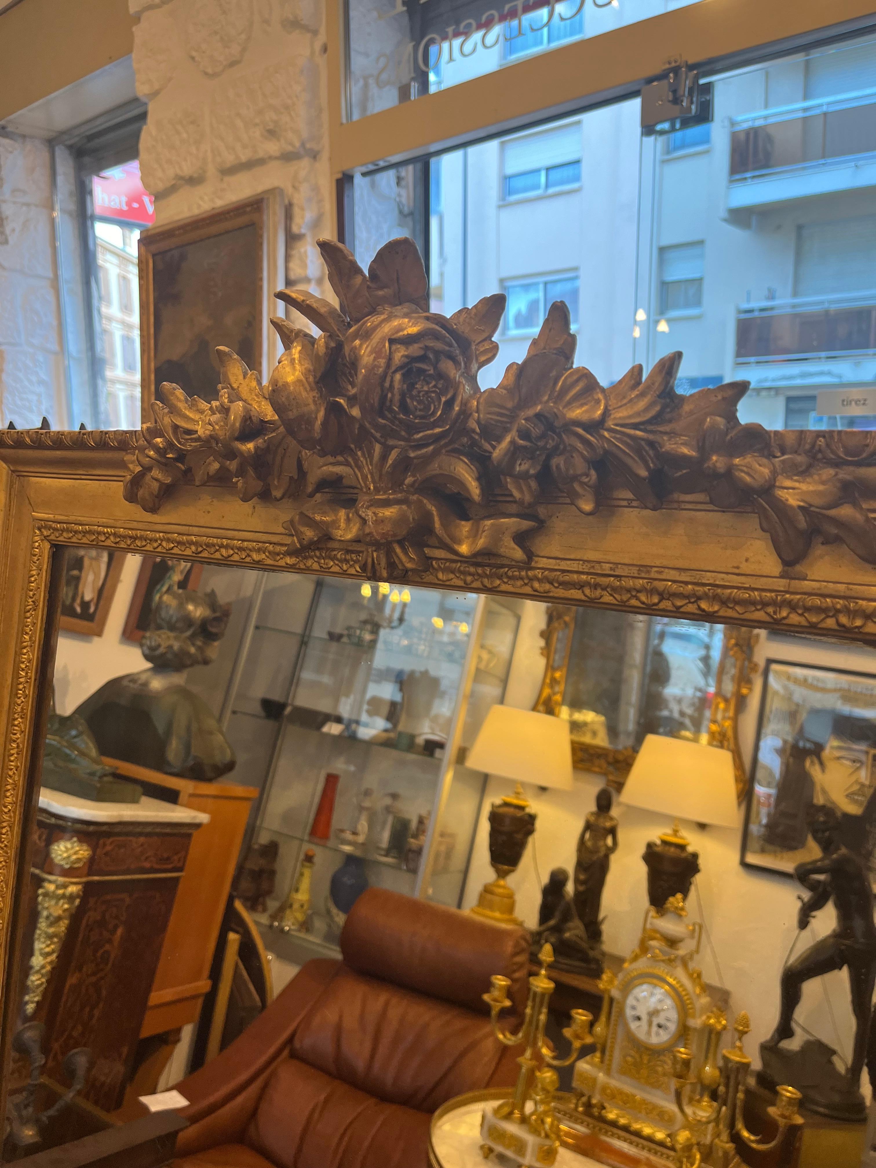 Wichtiger Spiegel aus vergoldetem Holz, oben mit einem Blumenstrauß verziert Frankreich 19.