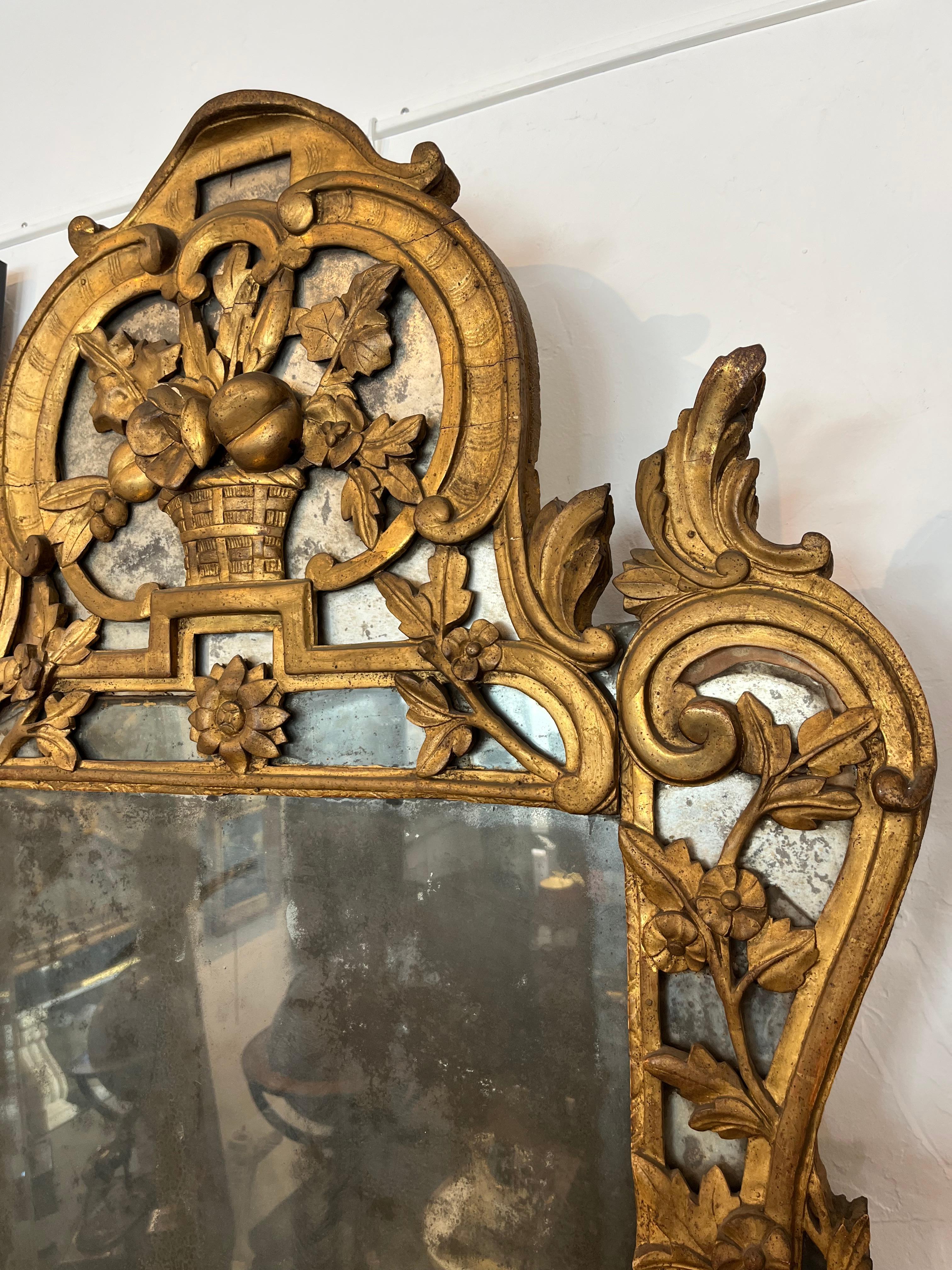 Important Provençal mirror. Topped with a basket of fruit and richly decorated with floral motifs, arabesques and acanthus leaves. France 18th century
Good condition: some small minimal lacks (visible in the photos)