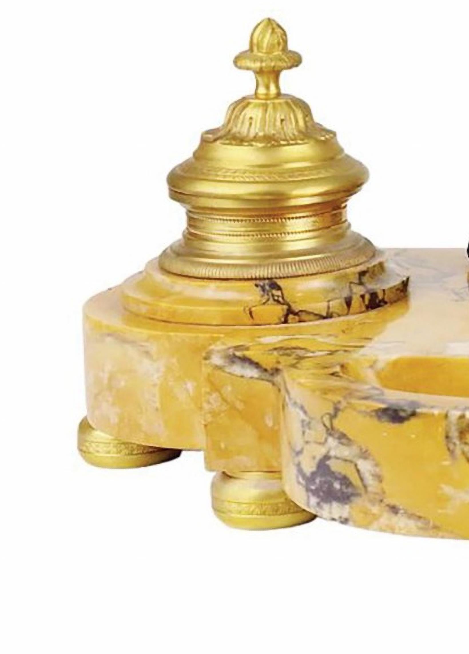 Important encrier au lion Napoléon III, 19e siècle
En marbre jaune de Sienne veiné, centré d'une tête de lion à la longue crinière en bronze à patine sombre, entouré de deux encriers en bronze doré finement ciselés tenant un petit réservoir en