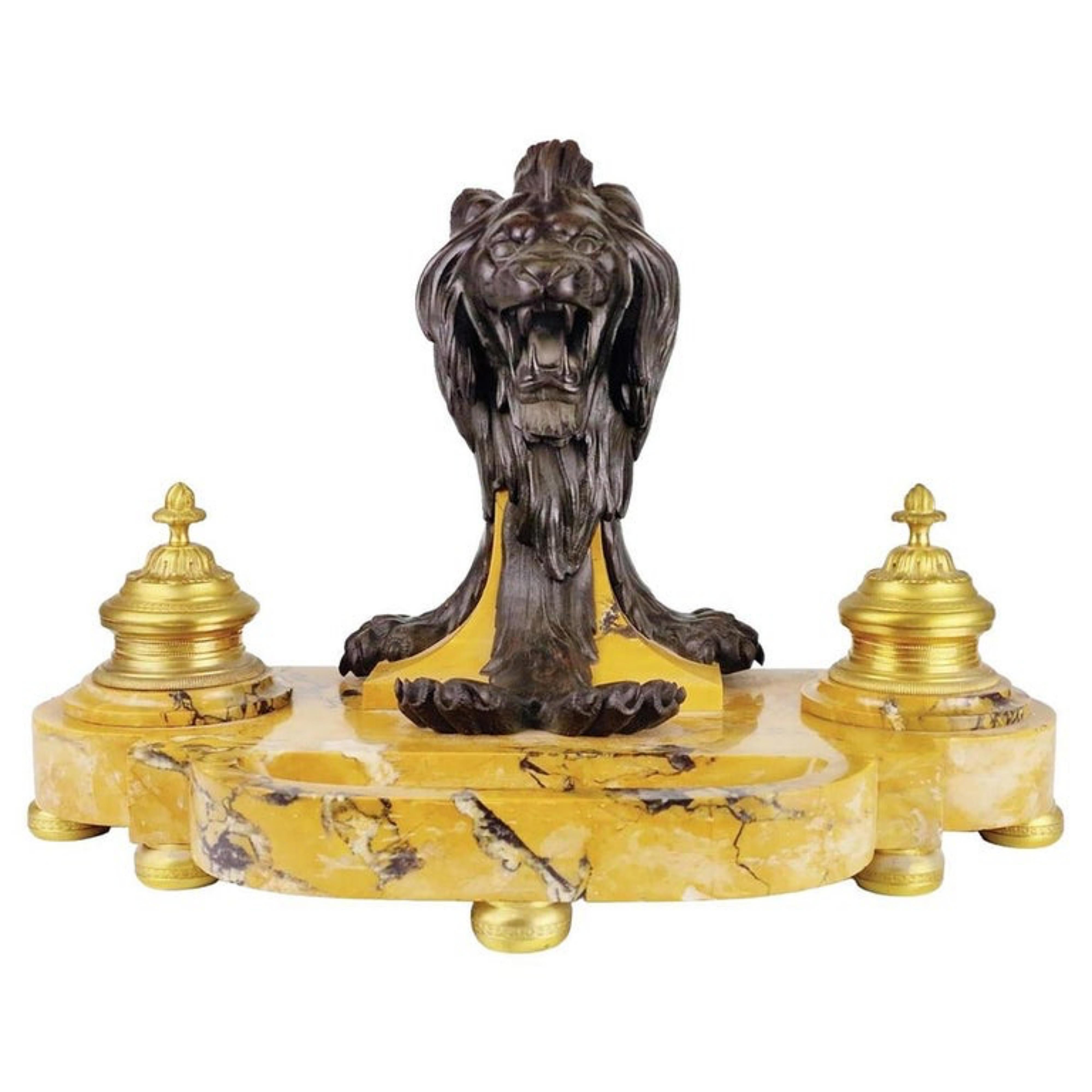 Importante tintero de león de Napoleón III, siglo XIX
En mármol de Siena amarillo veteado, centrado con una cabeza de león de larga melena en bronce con pátina oscura, rodeada de dos tinteros de bronce dorado finamente cincelados que sostienen un