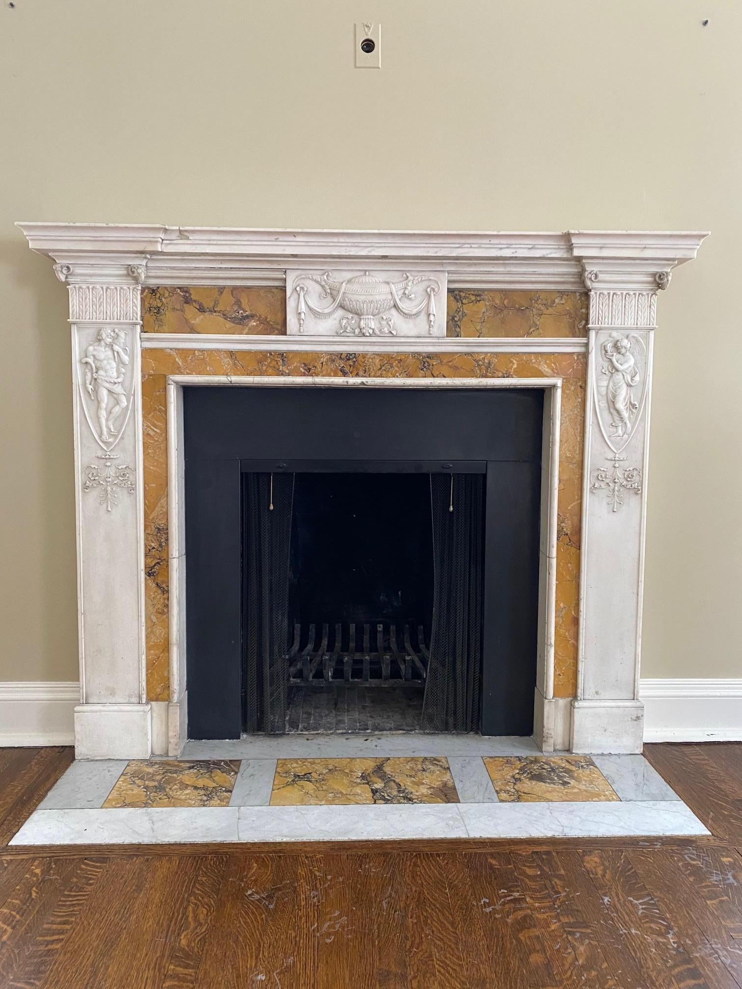 Important Georgian period fireplace mantel, white statuary marble and inset with Siena . The finely carved Neo -Classical attributes featuring a central cartouche relief cavings of a Neo-Classical urn flanked by relief carvings of 