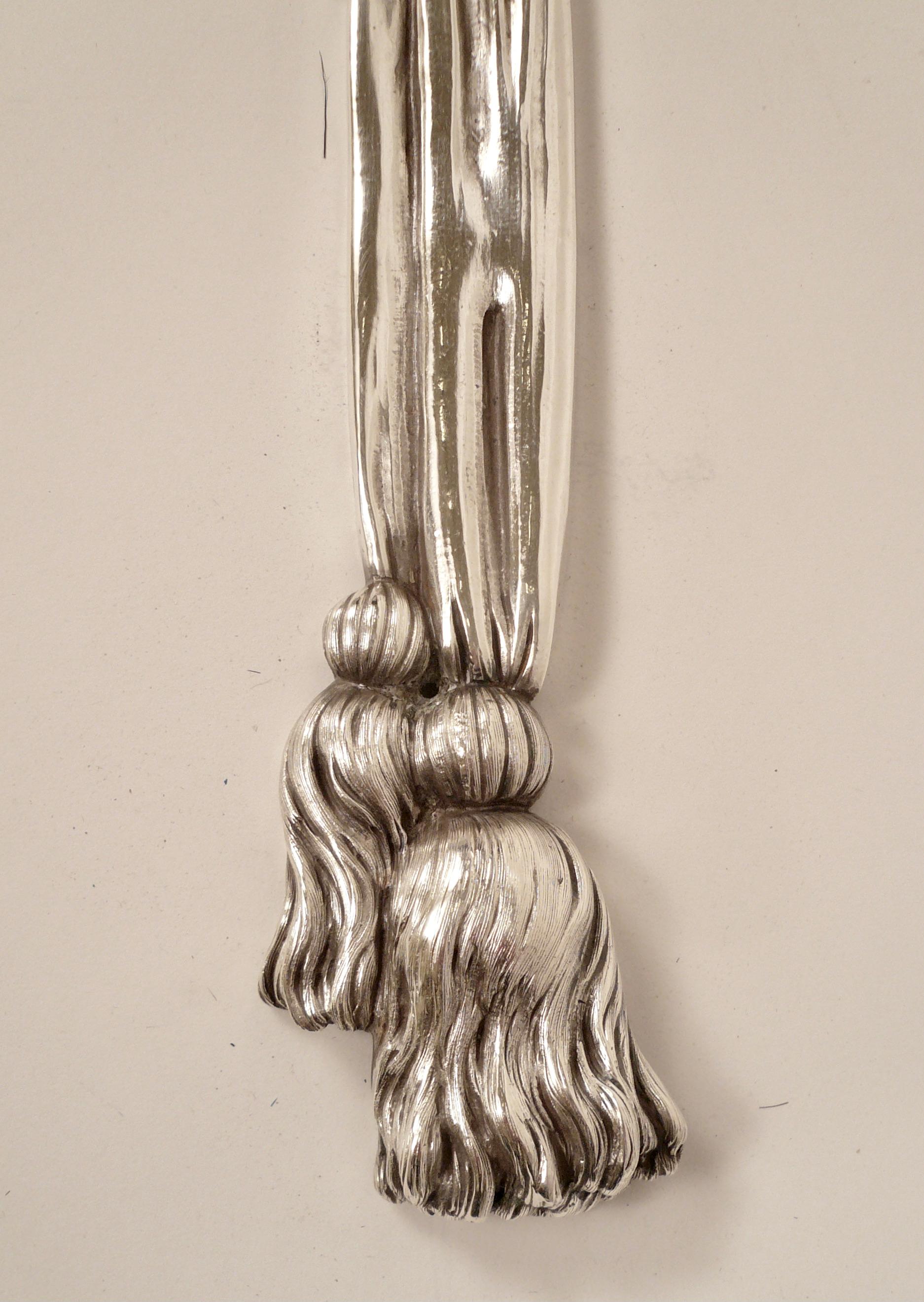 Dieses beeindruckende Paar Caldwell-Leuchter, das an die skulpturalen Schnitzereien von Grinling Gibbons erinnert, weist Schleifen, Bänder und Quasten auf. Zwischen den Bändern sind verschiedene Obstmotive gruppiert.
Das originale Silber ist in