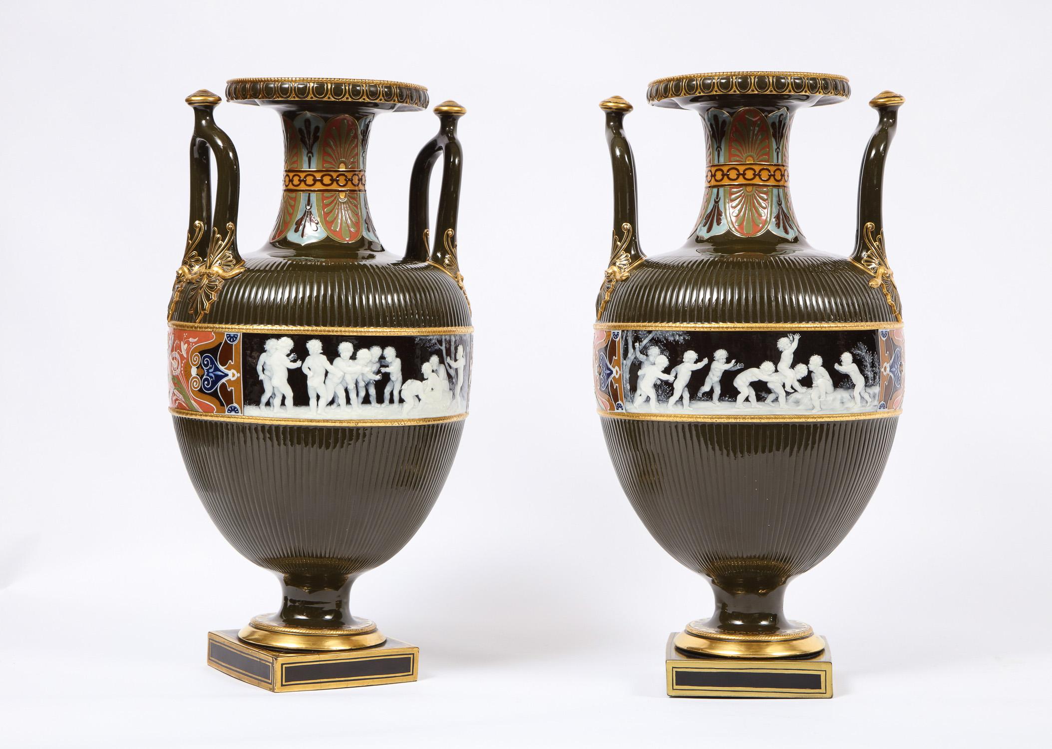 A magnificent and very large pair of antique Minton porcelain Pate Sur Pate vases with multi-paneled neoclassical scenes. In a gorgeous neoclassical style Amphora form with an olive green body, further adorned with beautiful multicolored red, blue