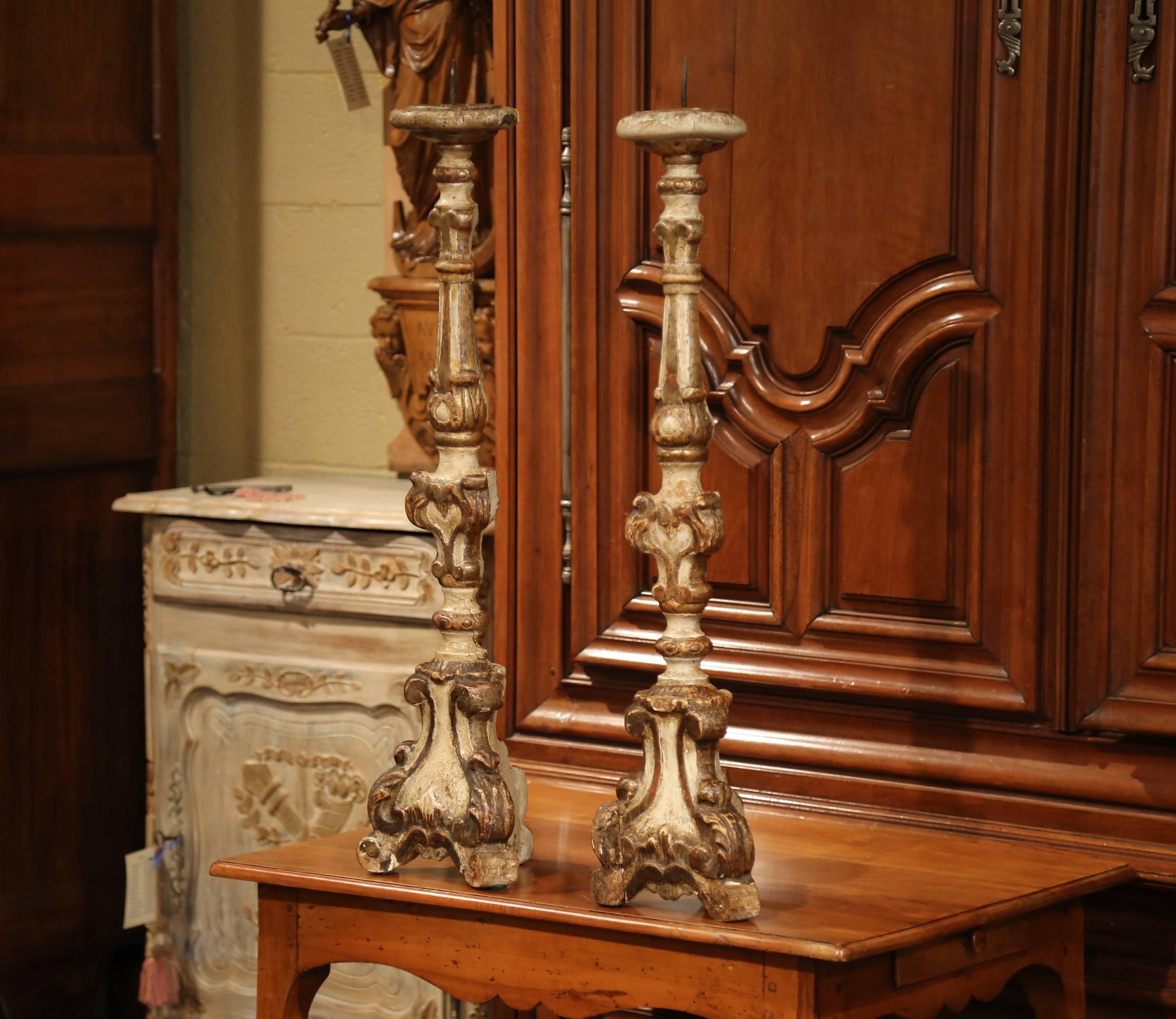 Add an air of drama and elegance to your home with this pair of antique candlesticks from Italy. Carved, circa 1760, each tall pricket has a sturdy triangle base with hand-carved acanthus leaves above three small feet, and a long carved decorative