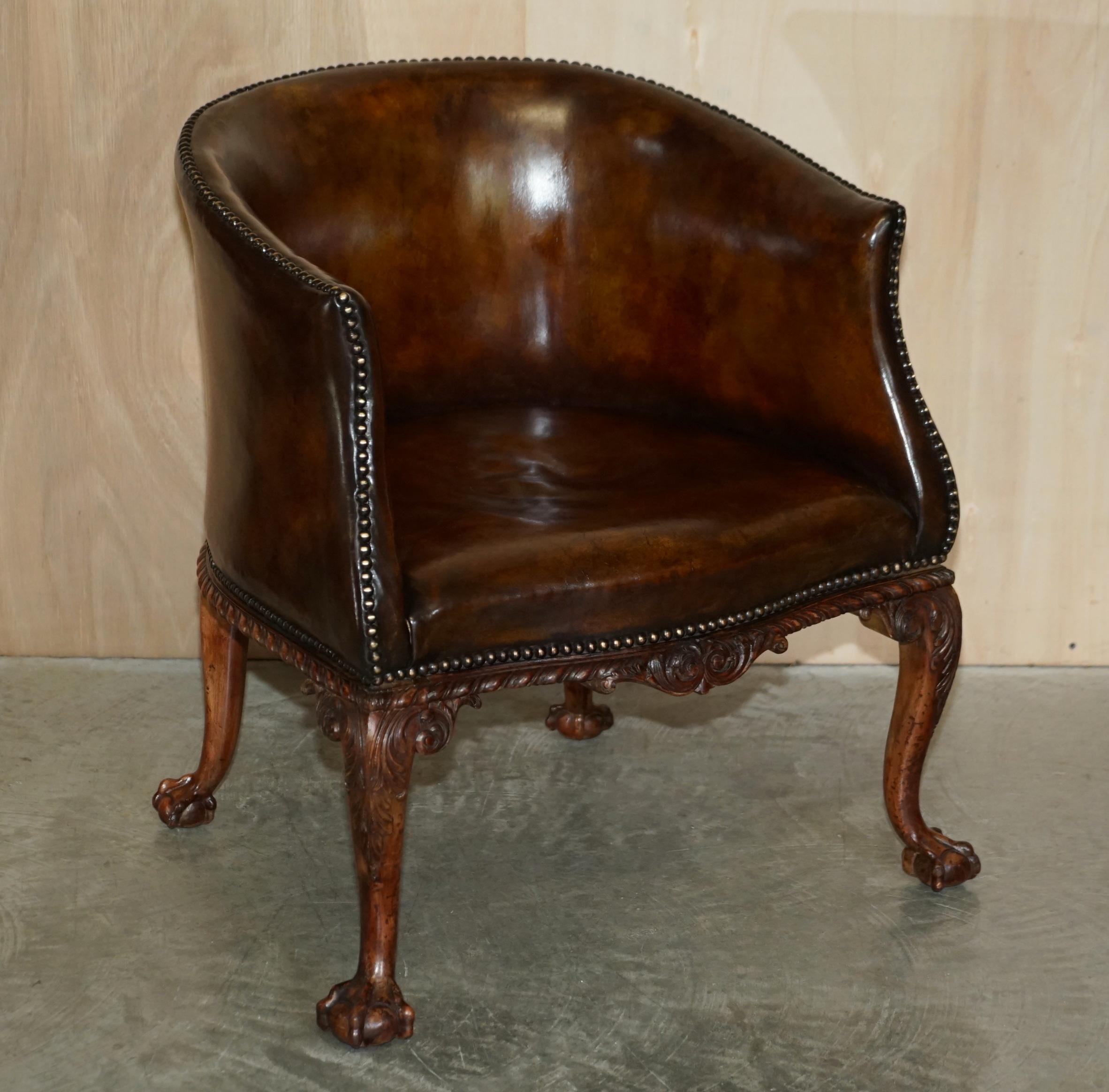 Nous avons le plaisir de proposer à la vente cette importante paire de fauteuils de bibliothèque de style Thomas Chippendale, lourdement sculptés avec des pieds cabriolets griffes et boules, en cuir brun.

Il s'agit de la plus belle paire de