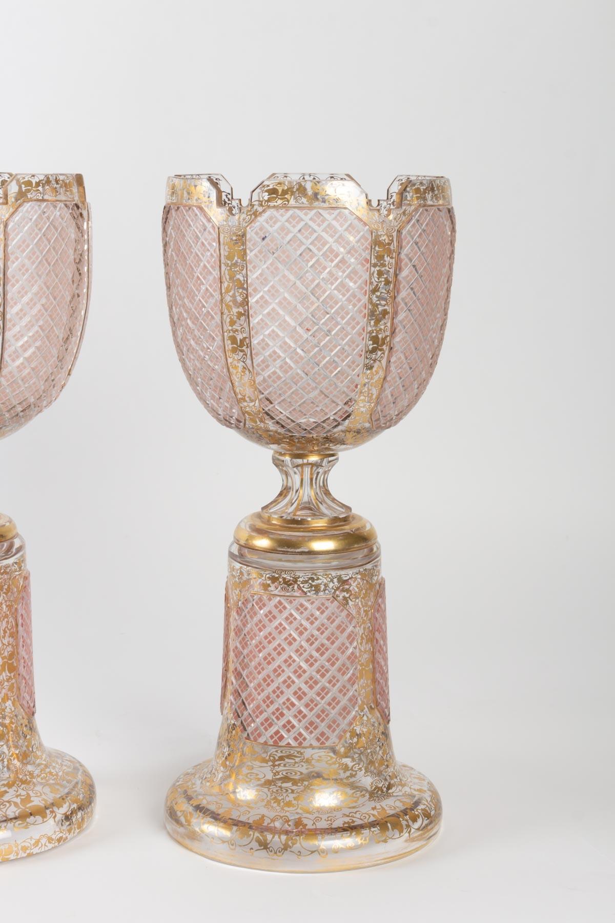 Pair of bohemian crystal cupscut,

rose on stand, with golden floral and vegetal

decoration, beautiful quality.

Late 19th century, Napoleon III Period

Measures: H 46cm, D 20cm.