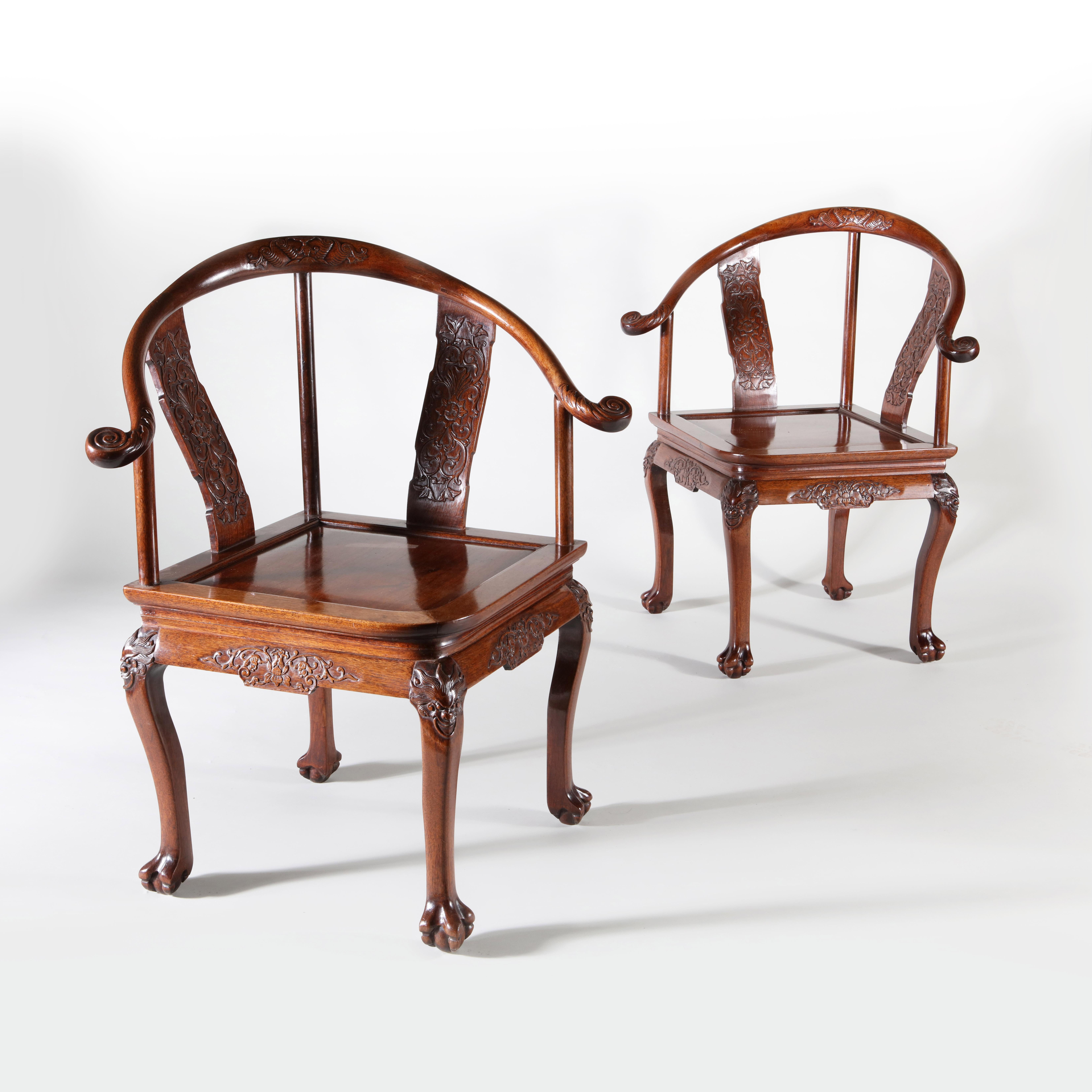 A rare pair of late 18th century Chinese Huang Huali armchairs with yoke backs terminating in scrolls and supported by splats and columns, centered around a traditional paneled seat with cabriole legs carved with dragons at the knee and terminating