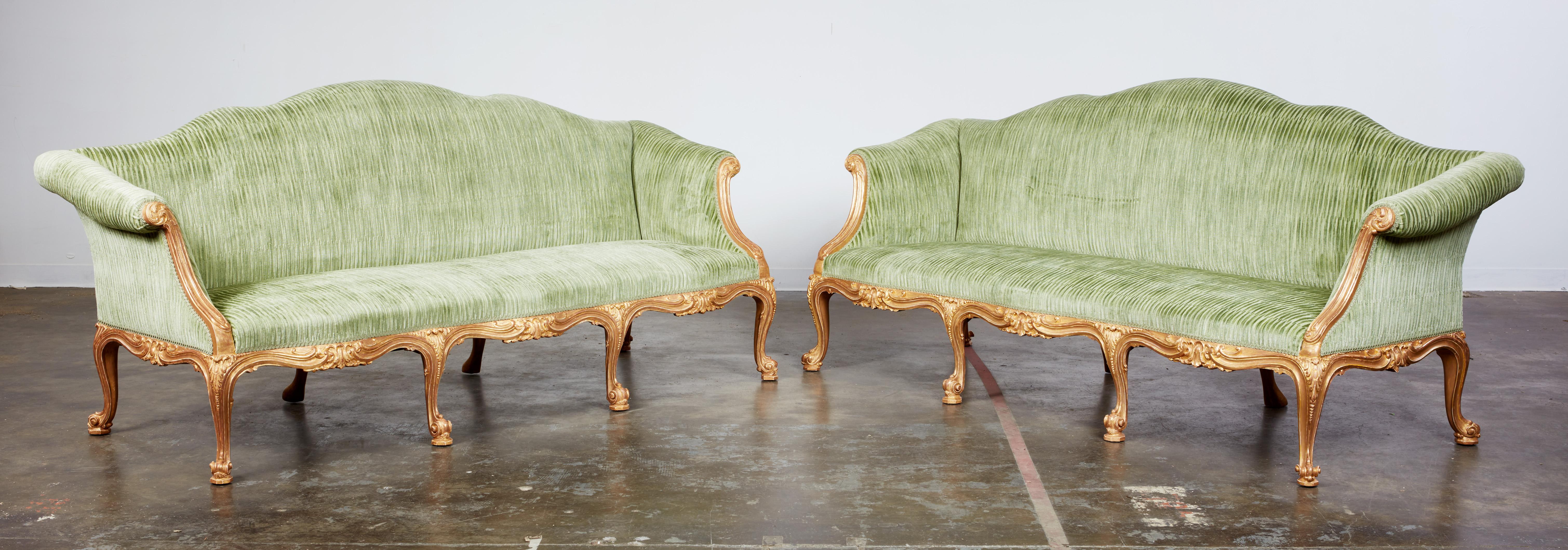 Very important pair of George III gilt wood rococo sofas attributed to John Cobb, the arched shaped back over scrolled arms with acanthus leaf carving, over triple serpentine seat, the frame with foliate and rocaille carving, standing on scroll