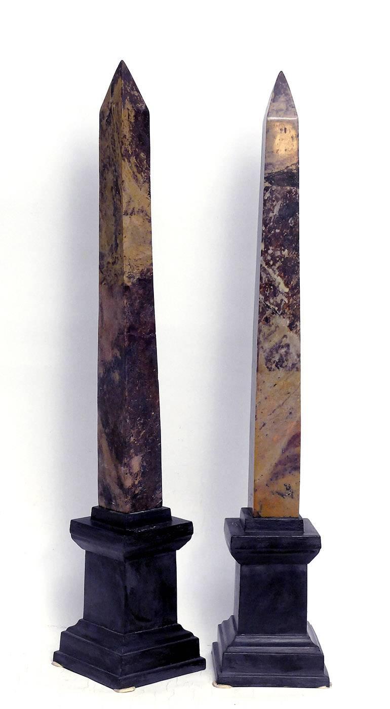 An important pair of obelisks, Grand Tour, made out of marble, with black painted metal base.