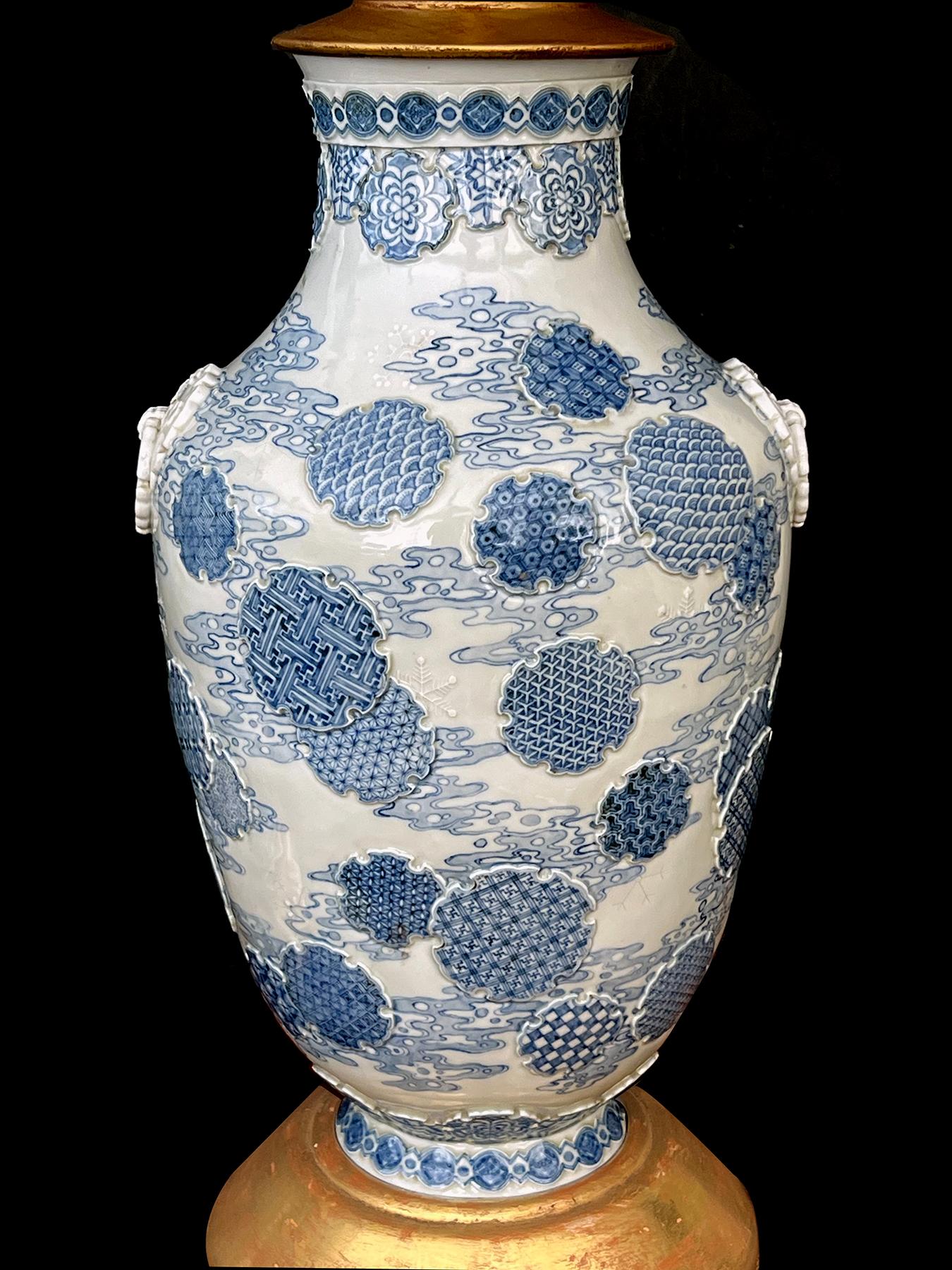 each ovoid vase with raised decoration at the neck and adorned overall with raised medallions all on a pale blue ground with painted cloud scrolls; the vase flanked by applied ring handles; each marked on underside; the vases were vetted in 1992 by