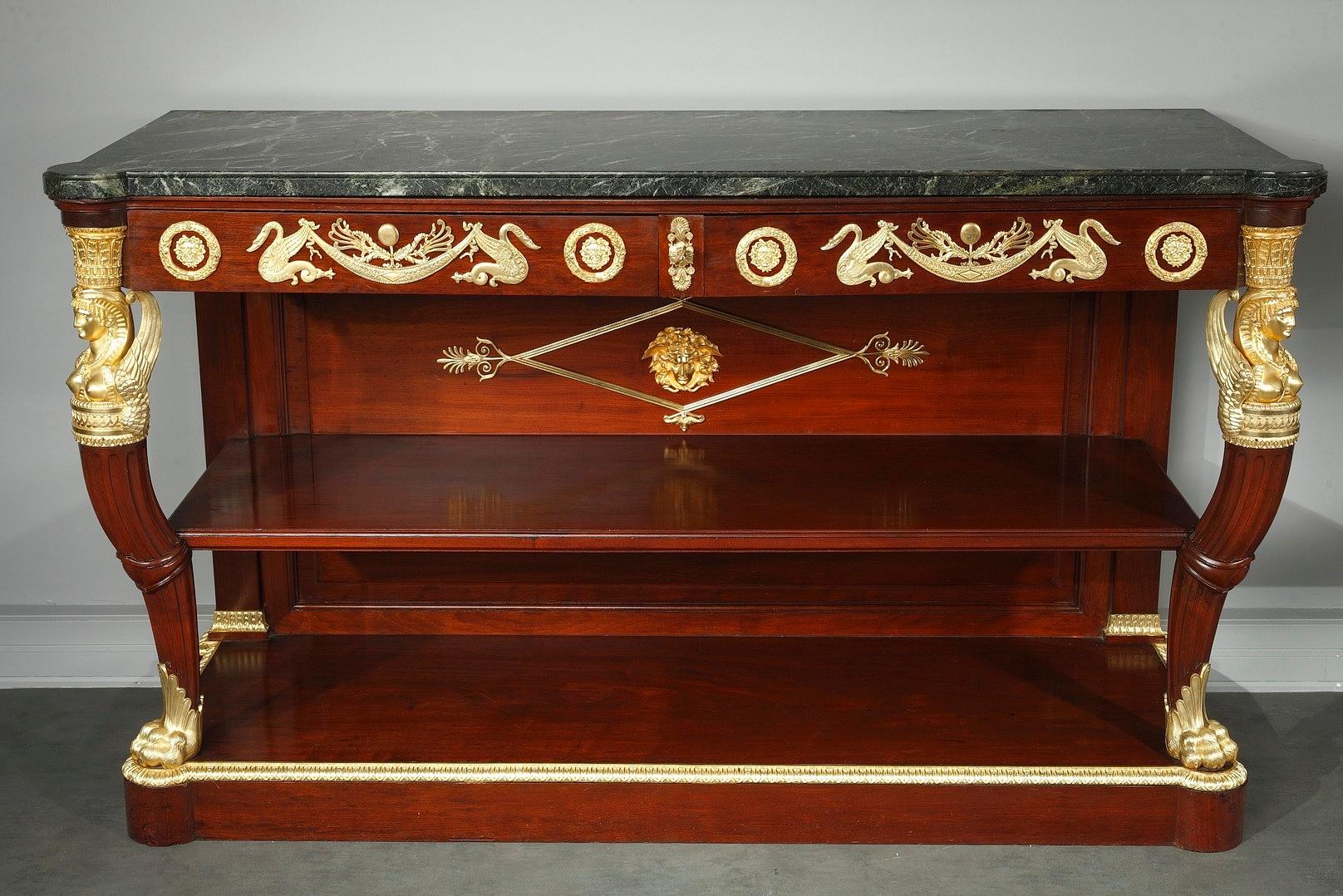 Important pair of mahogany and mahogany veneer console tables with exquisite gilt bronze decoration. The belt features two drawers highlighted with swans and masks in medallions. Supporting the marble-topped table are graceful cabriole legs, that
