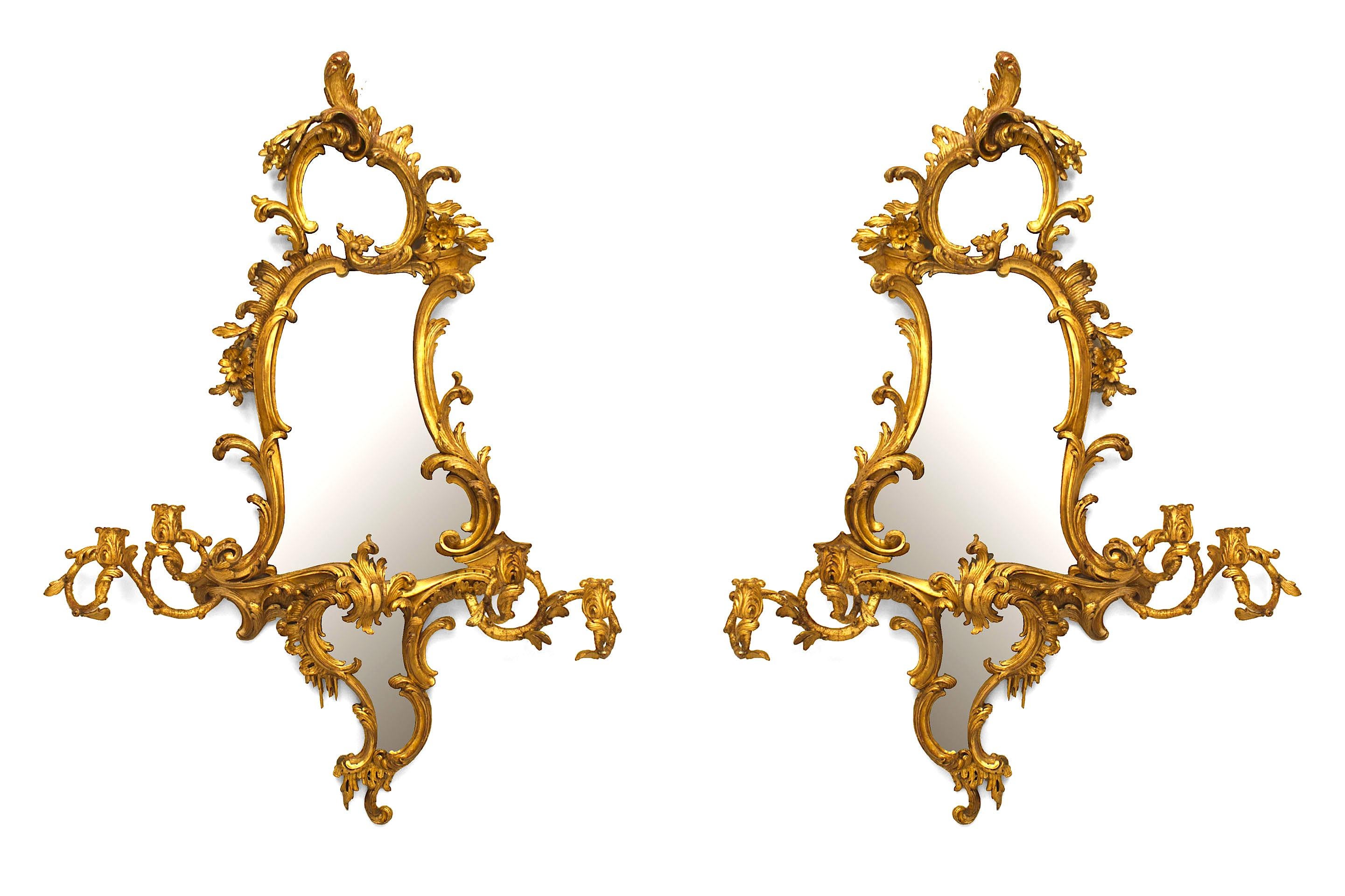 Pair of English George II (circa 1750) giltwood shaped form wall mirrors / girandoles with elaborate carved scroll designs and two Pairs of lights emanating from the center. (PRICED AS Pair)
