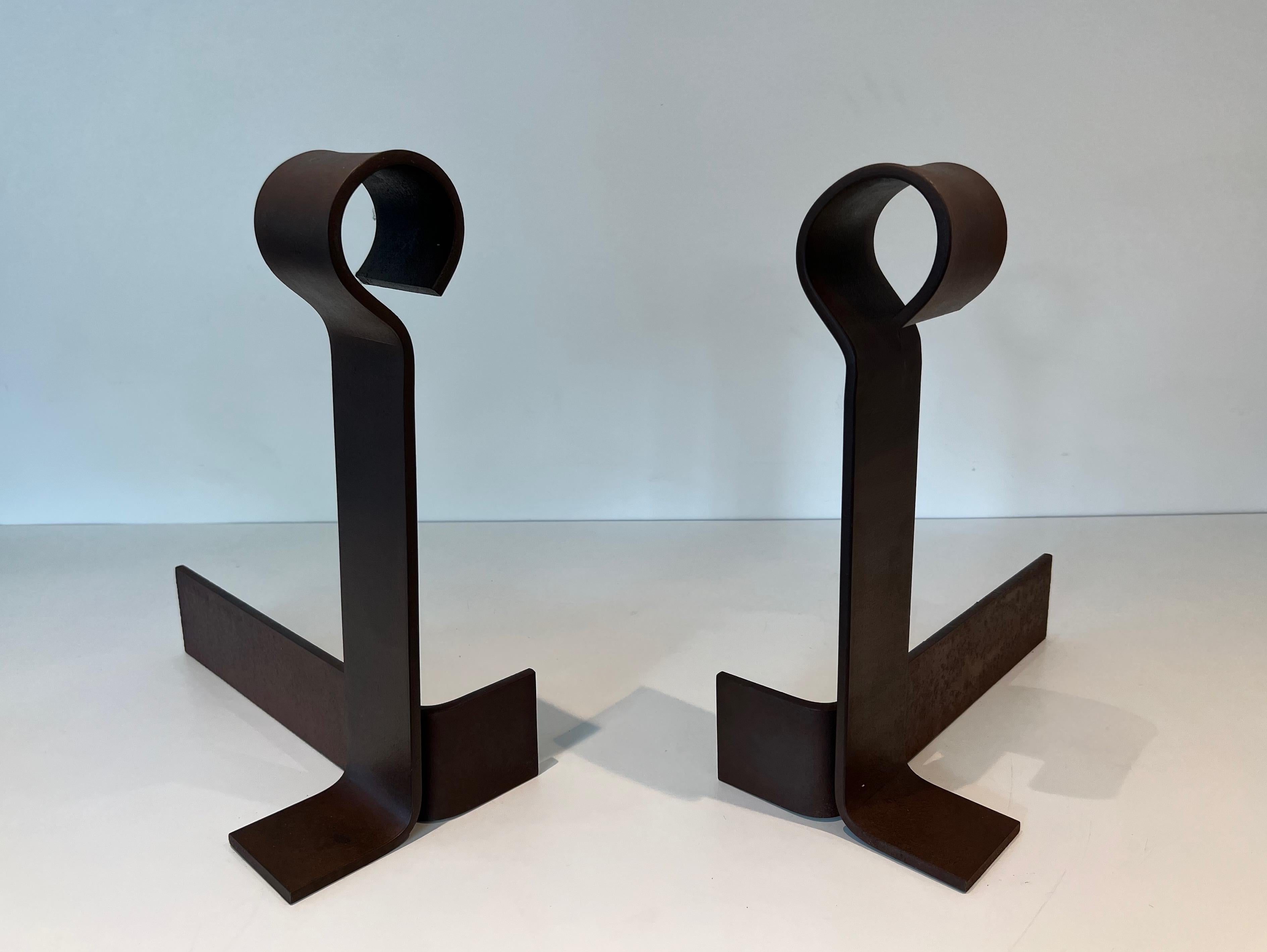 This important pair of modernist andirons is made of cast iron and wrought iron. These firedogs are particularly tall. This is a French work. Circa 1940