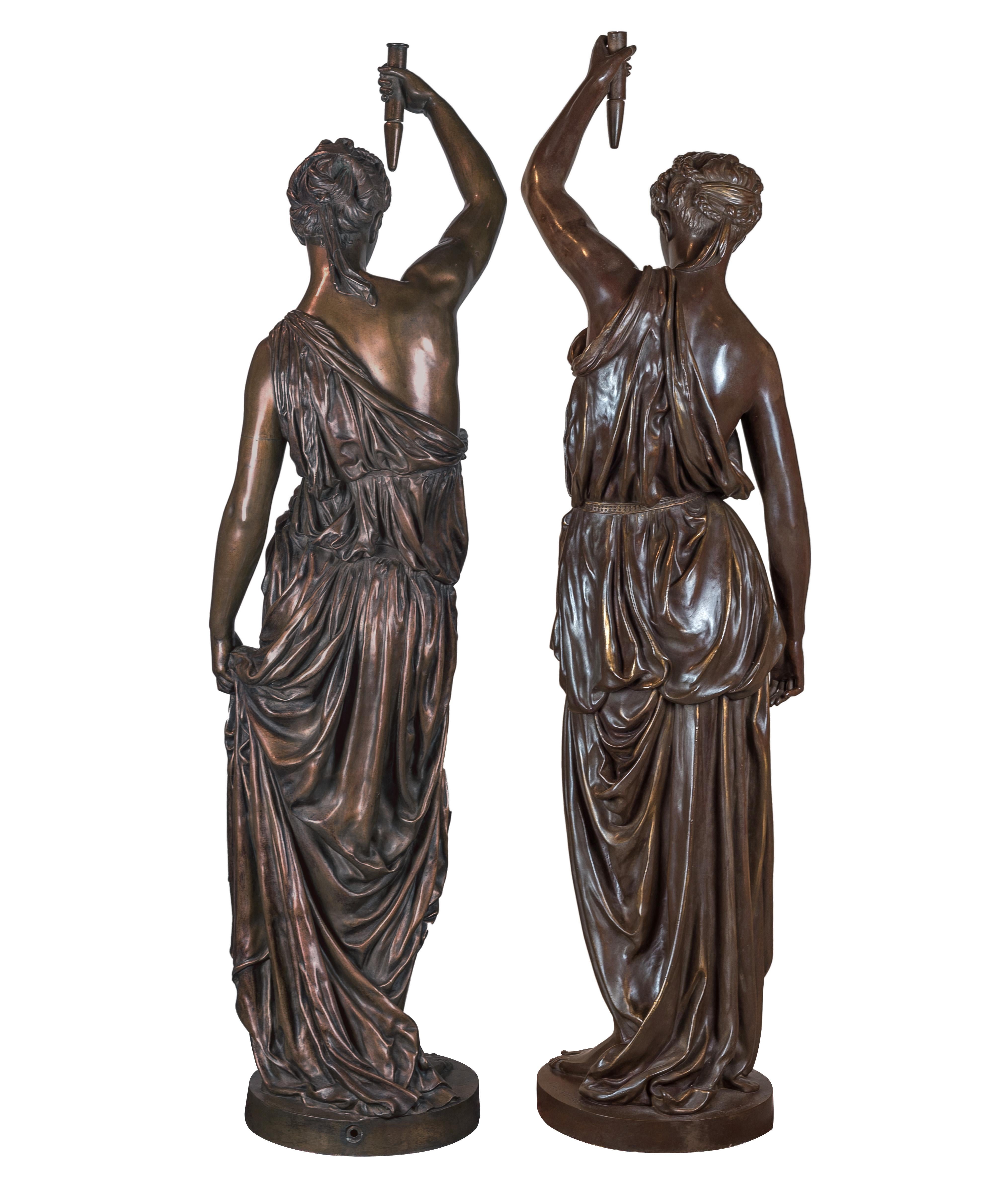 Français Importante paire de torchères monumentales figuratives en bronze patiné et doré à la feuille en vente