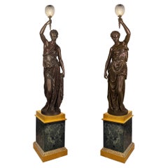 Importante paire de torchères monumentales figuratives en bronze patiné et doré à la feuille