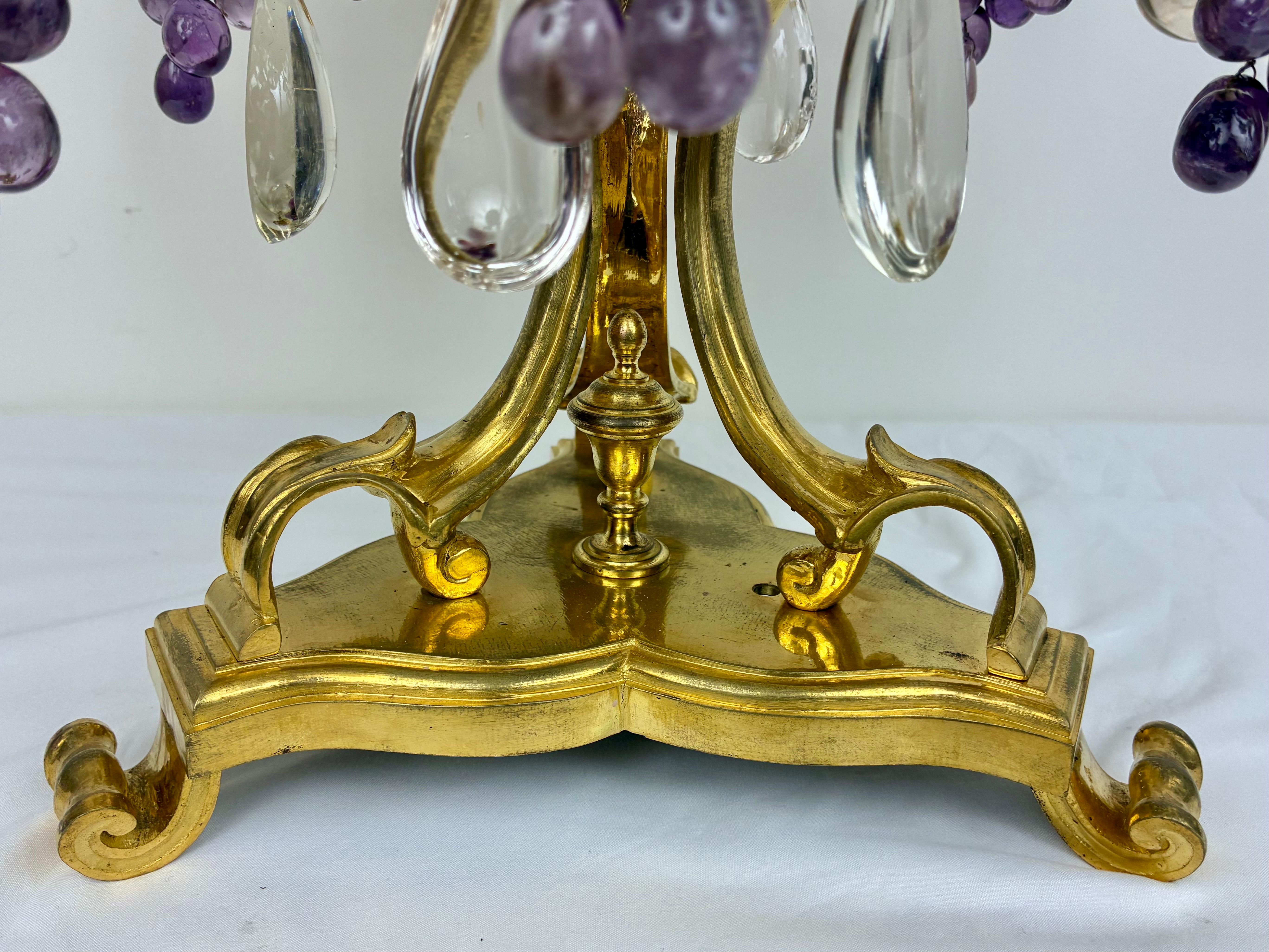 This fabulous and impressive pair of gilt bronze girandoles or candelabra are by the renowned French firm of Maison Bagues.  They are of grand proportions, and feature hand carved quartz crystal fruits, leaves, drops, and rosettes.